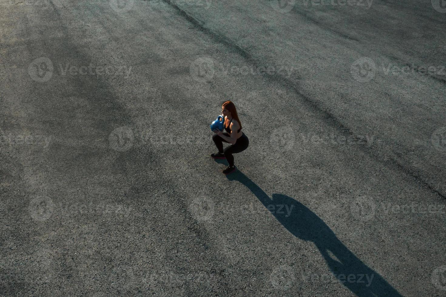 soulever des poids. vue de dessus d'une femme qui a une journée de remise en forme sur la route le soir photo
