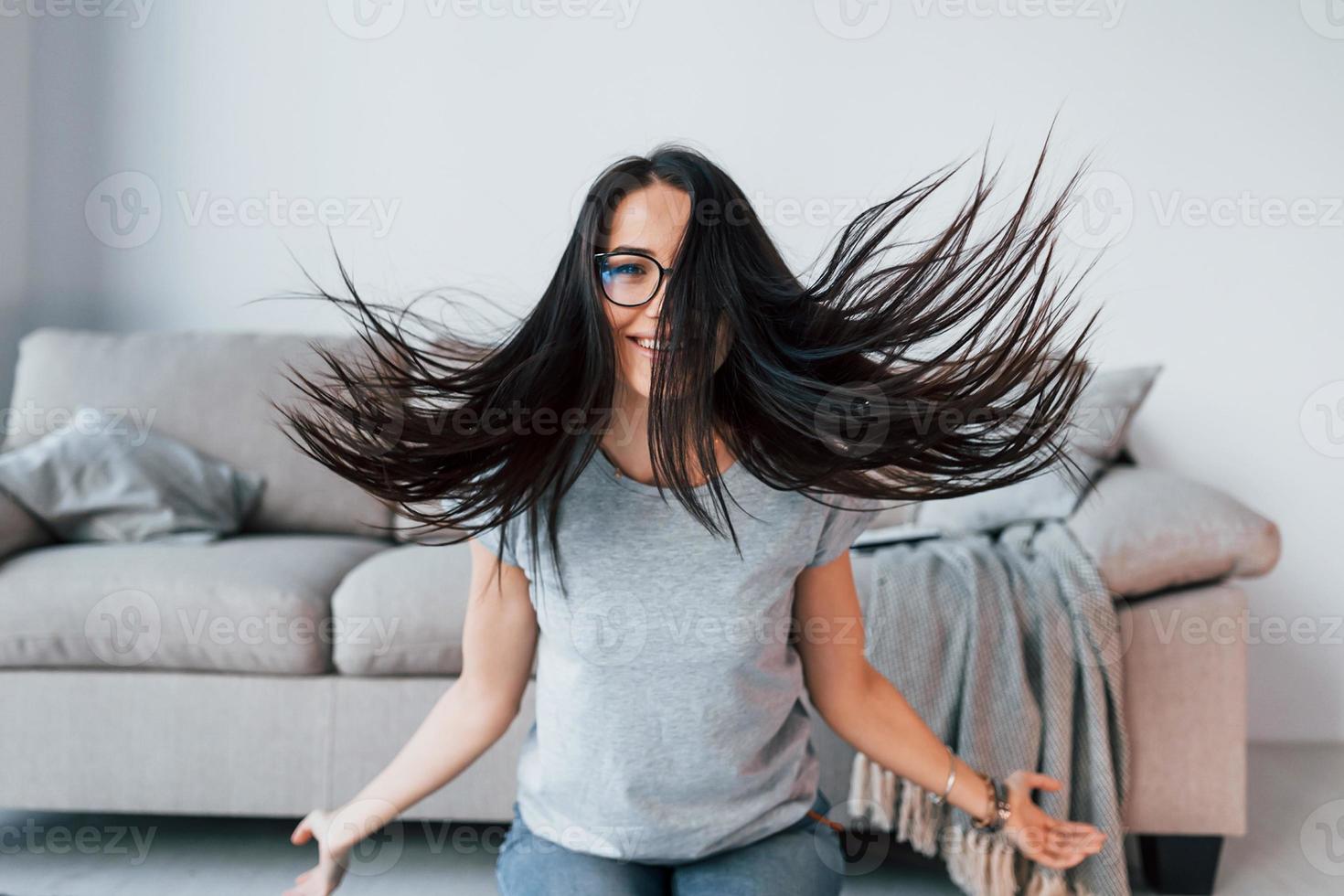 belle jeune femme en vêtements décontractés et lunettes s'amuser seule à la maison photo