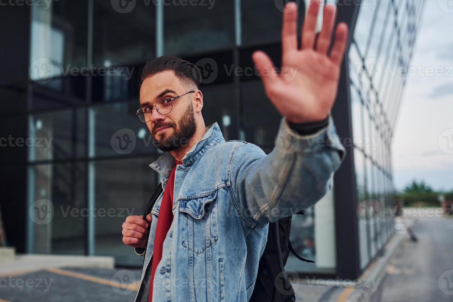 beau jeune homme en vêtements décontractés est à l'extérieur pendant la journée ensoleillée photo