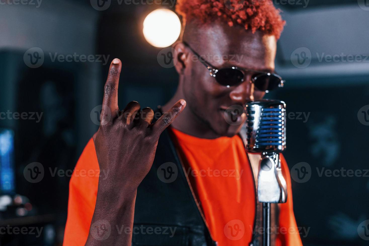 avoir une pratique vocale. jeune artiste afro-américain répétant dans un studio d'enregistrement photo