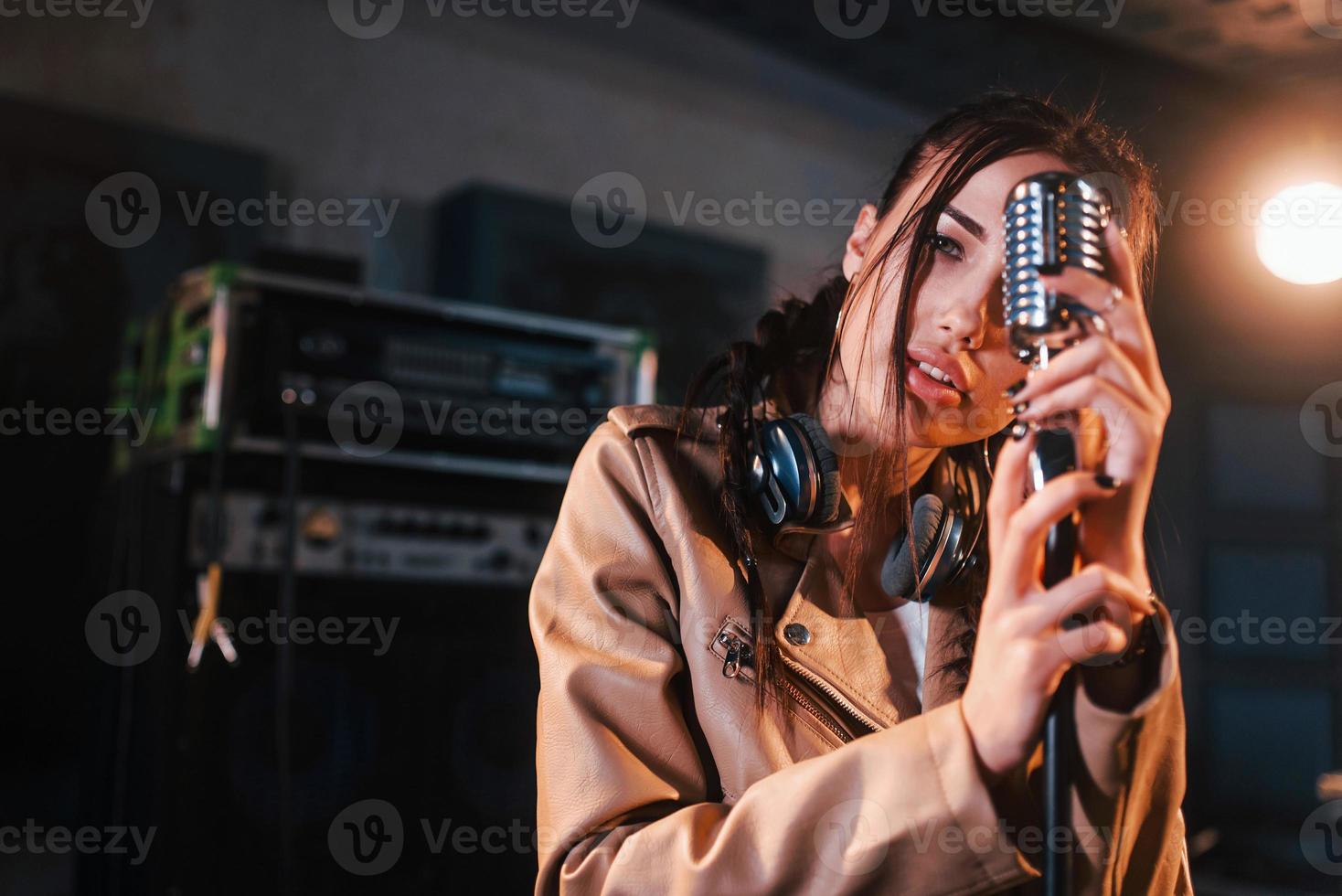 jeune belle interprète féminine chante et répète dans un studio d'enregistrement photo