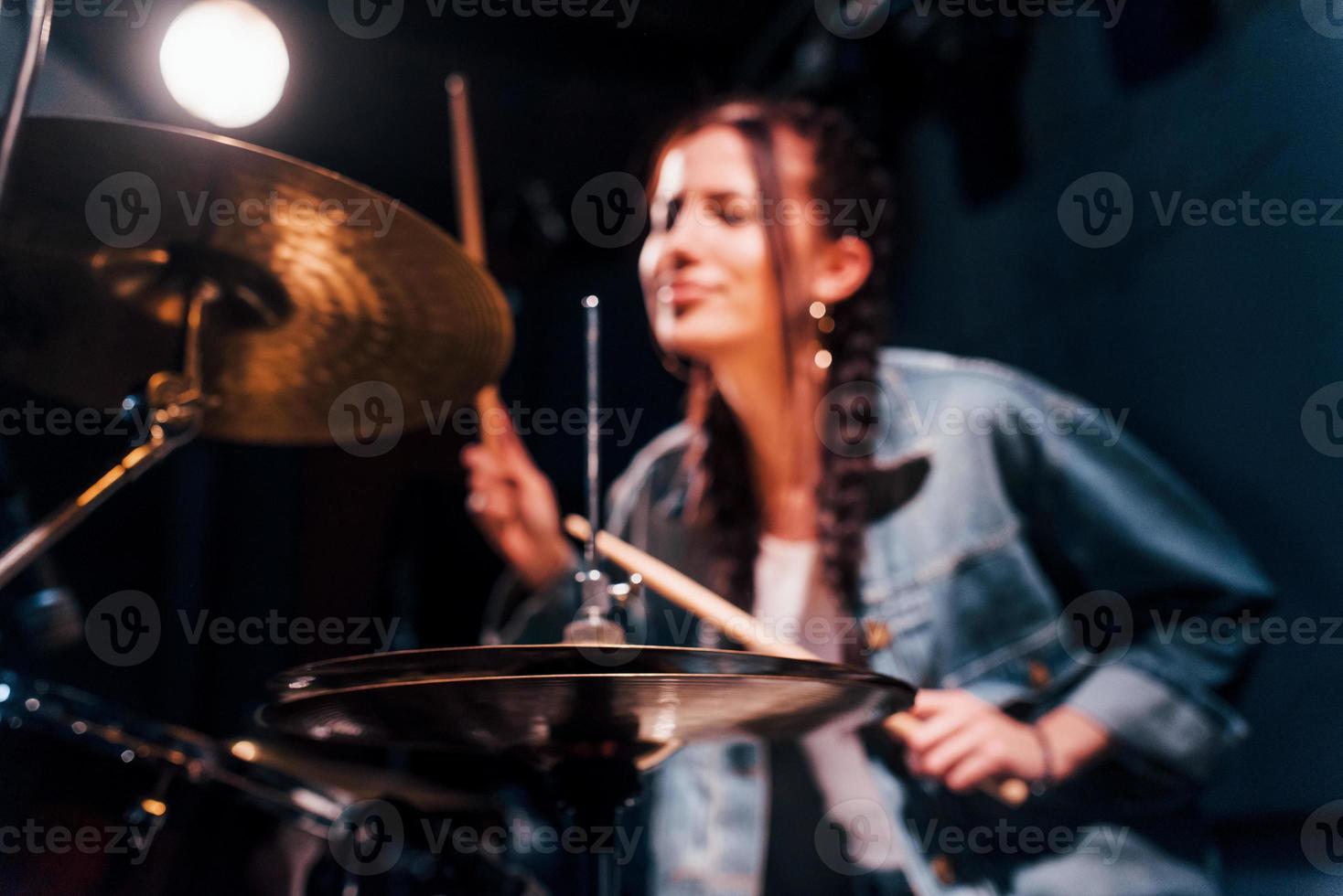 joue de la batterie. jeune belle interprète féminine répétant dans un studio d'enregistrement photo