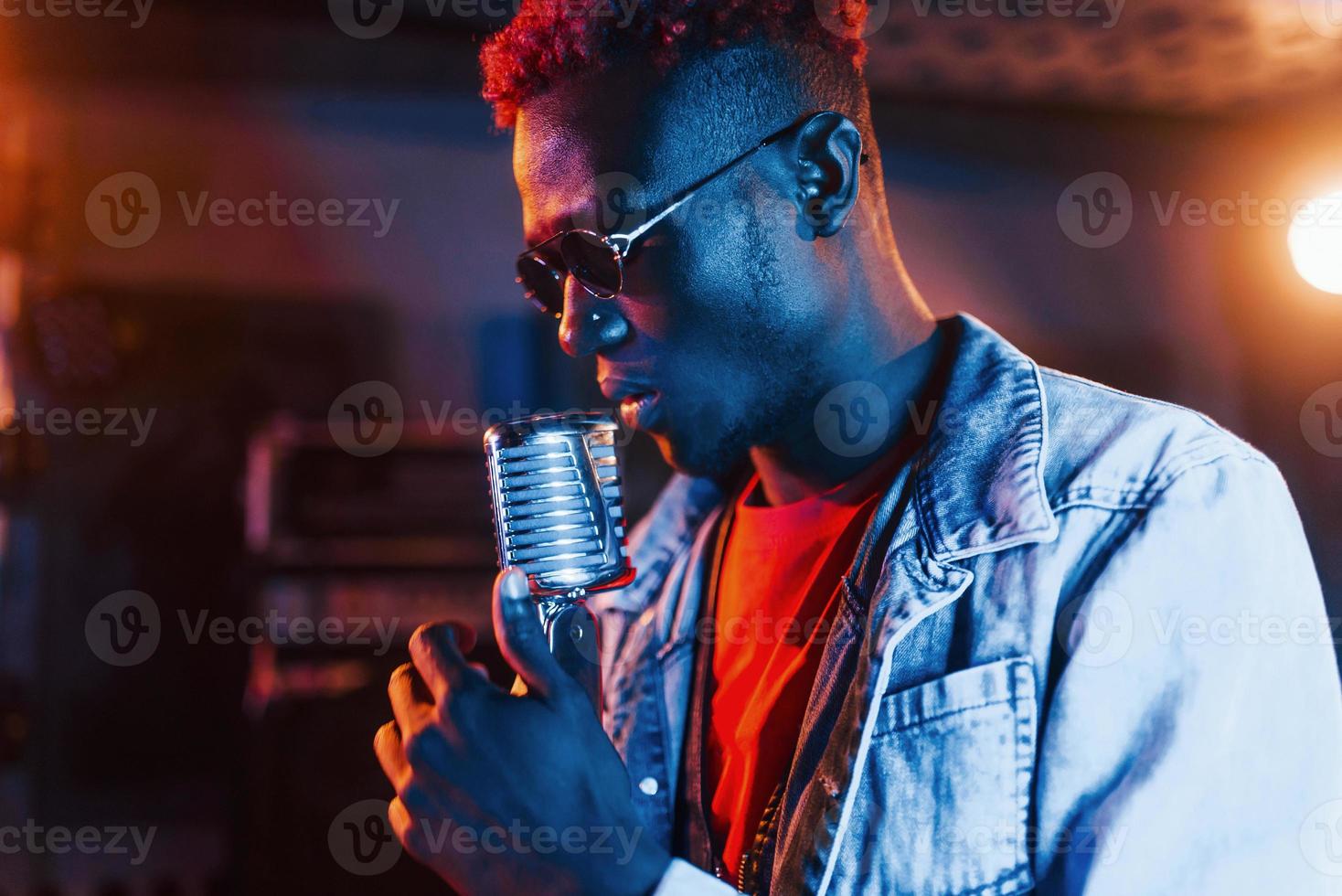 jeune artiste afro-américain répétant dans un studio d'enregistrement photo