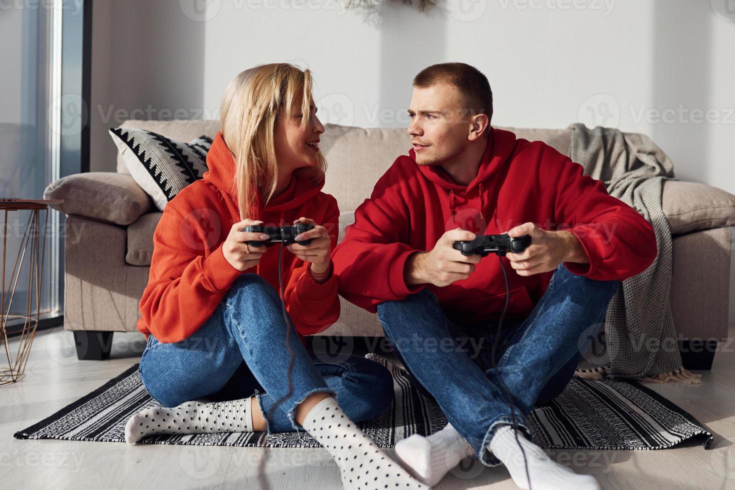 jeune couple charmant ensemble à la maison jouant à des jeux vidéo le week-end et les vacances ensemble photo