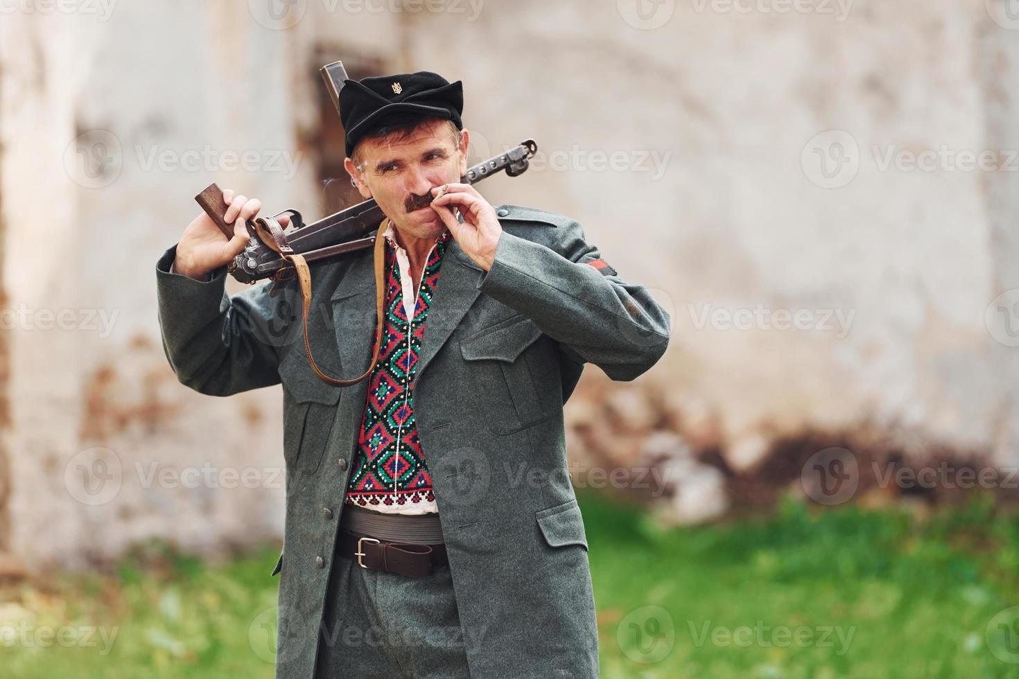 ternopil, ukraine - juin 2020 upa tournage d'un film de l'armée insurrectionnelle ukrainienne. photos des coulisses. vieux soldat avec arme fumant