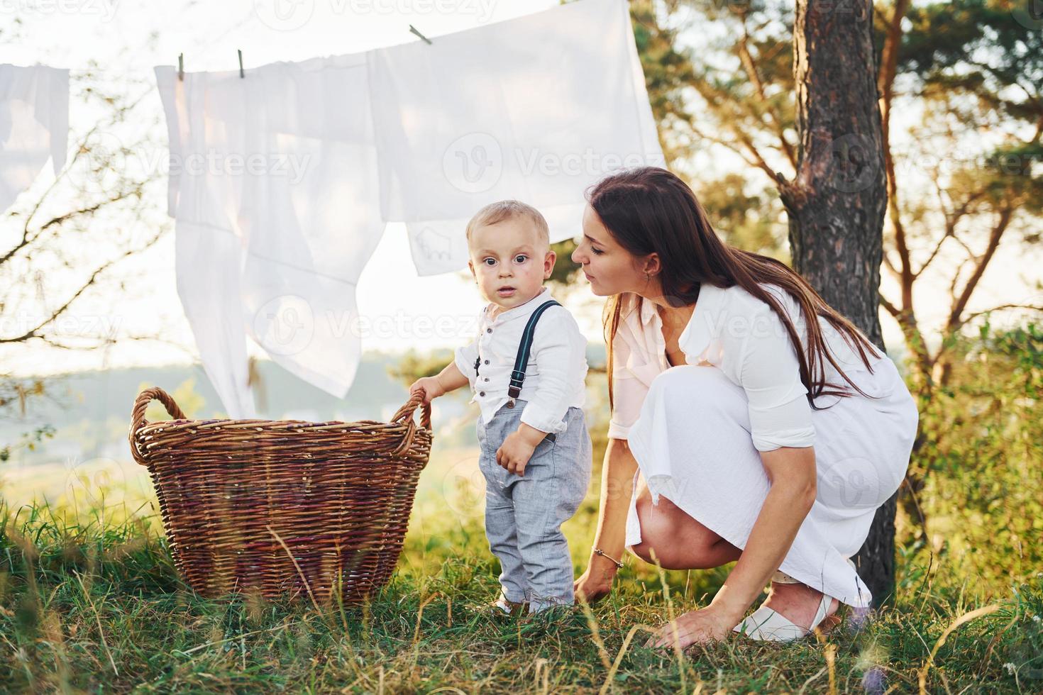 vêtements propres suspendus à la corde pour sécher. jeune mère avec son  petit fils est à l'extérieur dans la forêt. beau soleil 15300597 Photo de  stock chez Vecteezy