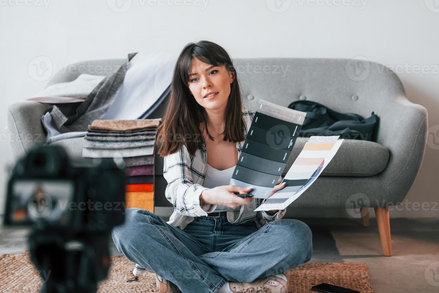 la caméra est au sol. la jeune travailleuse indépendante est à l'intérieur de la maison pendant la journée photo