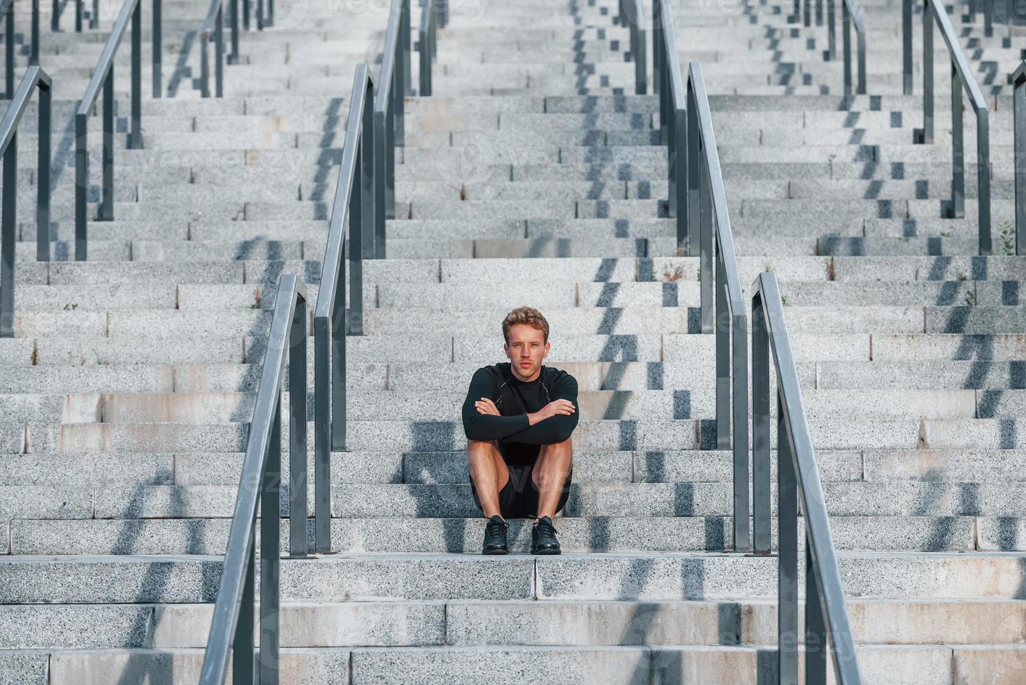 jeune homme en tenue sportive s'entraîne à l'extérieur pendant la journée photo