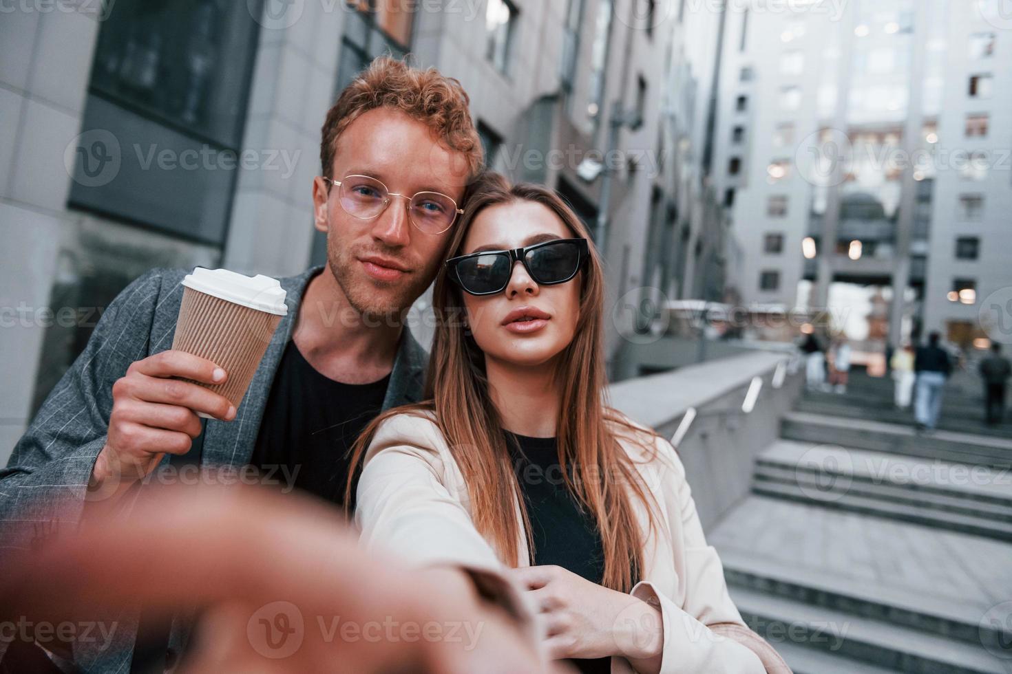 fait des selfies. femme et homme dans la ville pendant la journée. des gens bien habillés photo