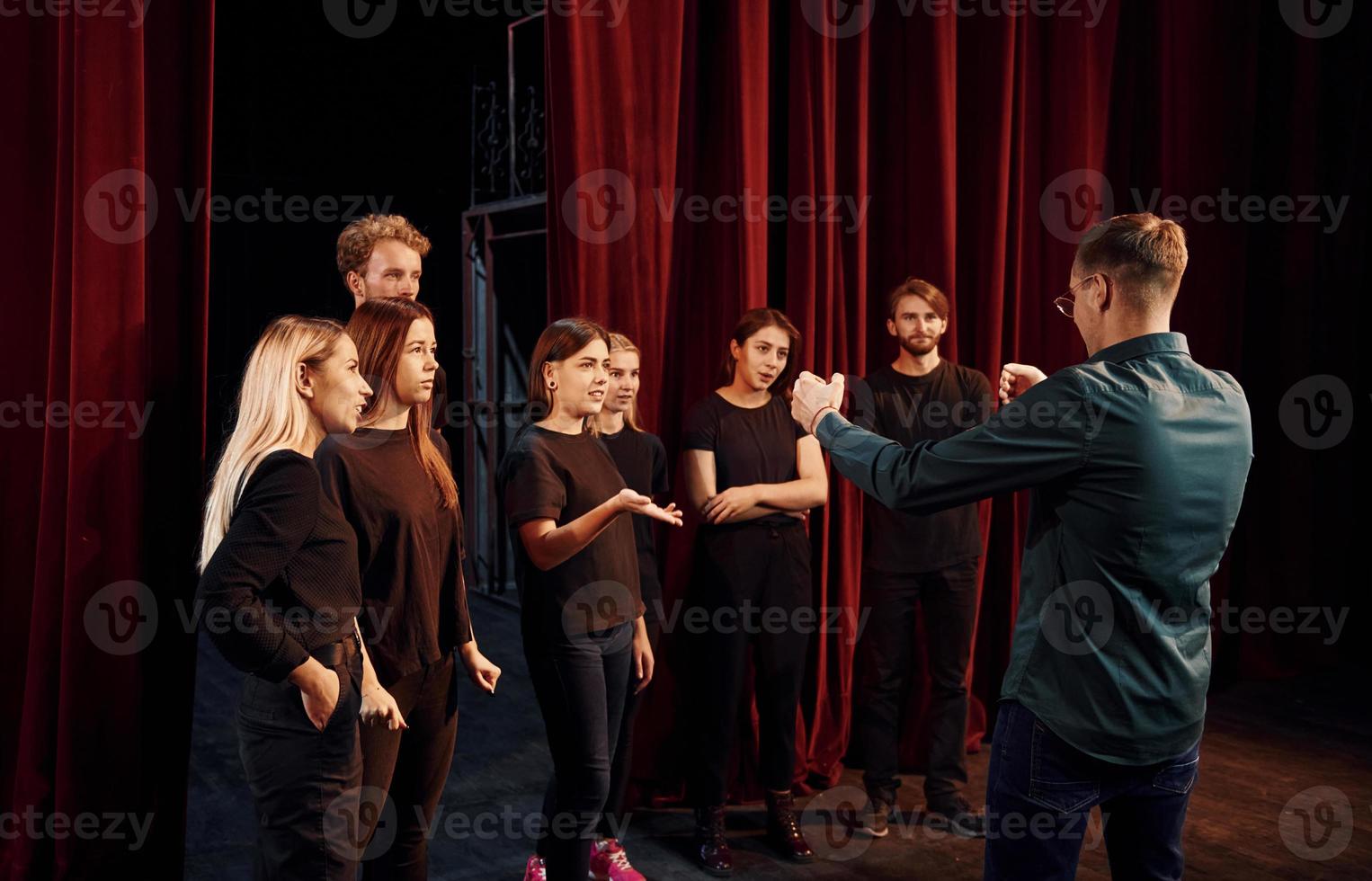 groupe d'acteurs vêtus de vêtements de couleur sombre en répétition au théâtre photo