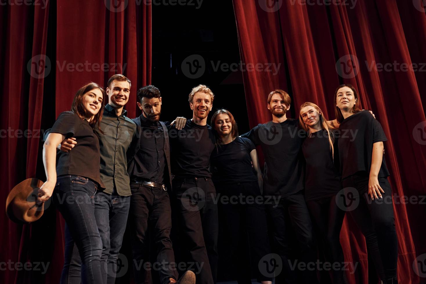 travailler ensemble. groupe d'acteurs vêtus de vêtements de couleur sombre en répétition au théâtre photo