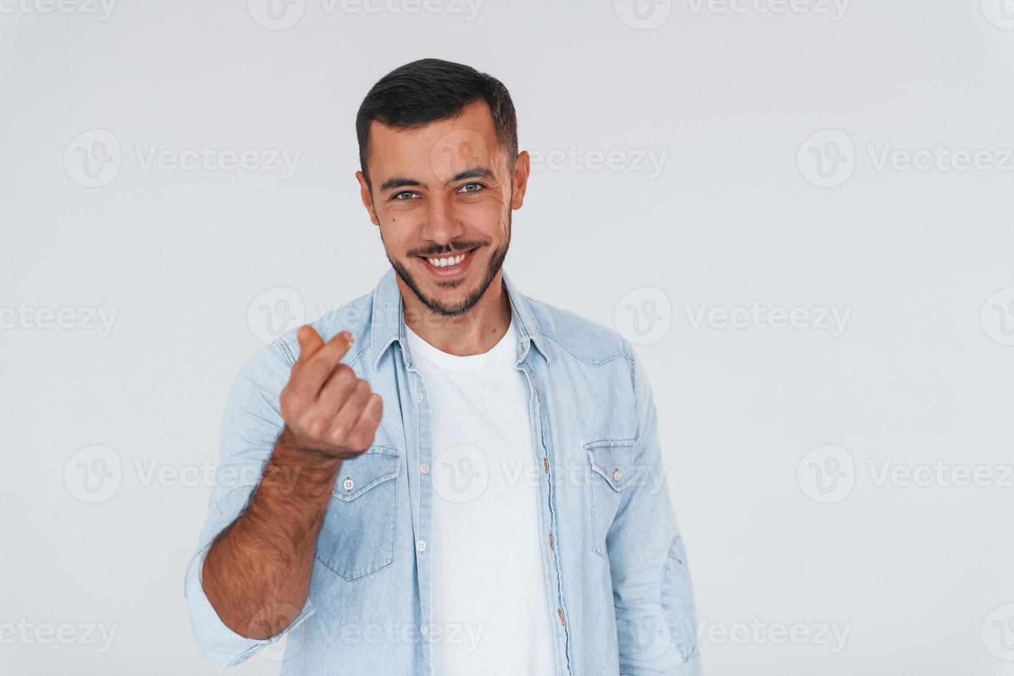 jeune bel homme debout à l'intérieur sur fond blanc photo