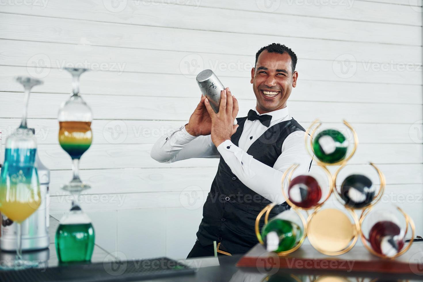 au bar. serveur noir en vêtements formels est à son travail à l'extérieur pendant la journée ensoleillée photo