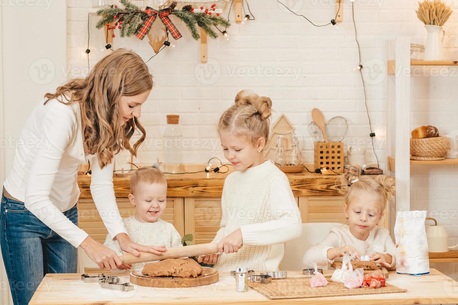 maman et filles caucasiennes préparent des biscuits de noël dans la cuisine. photo