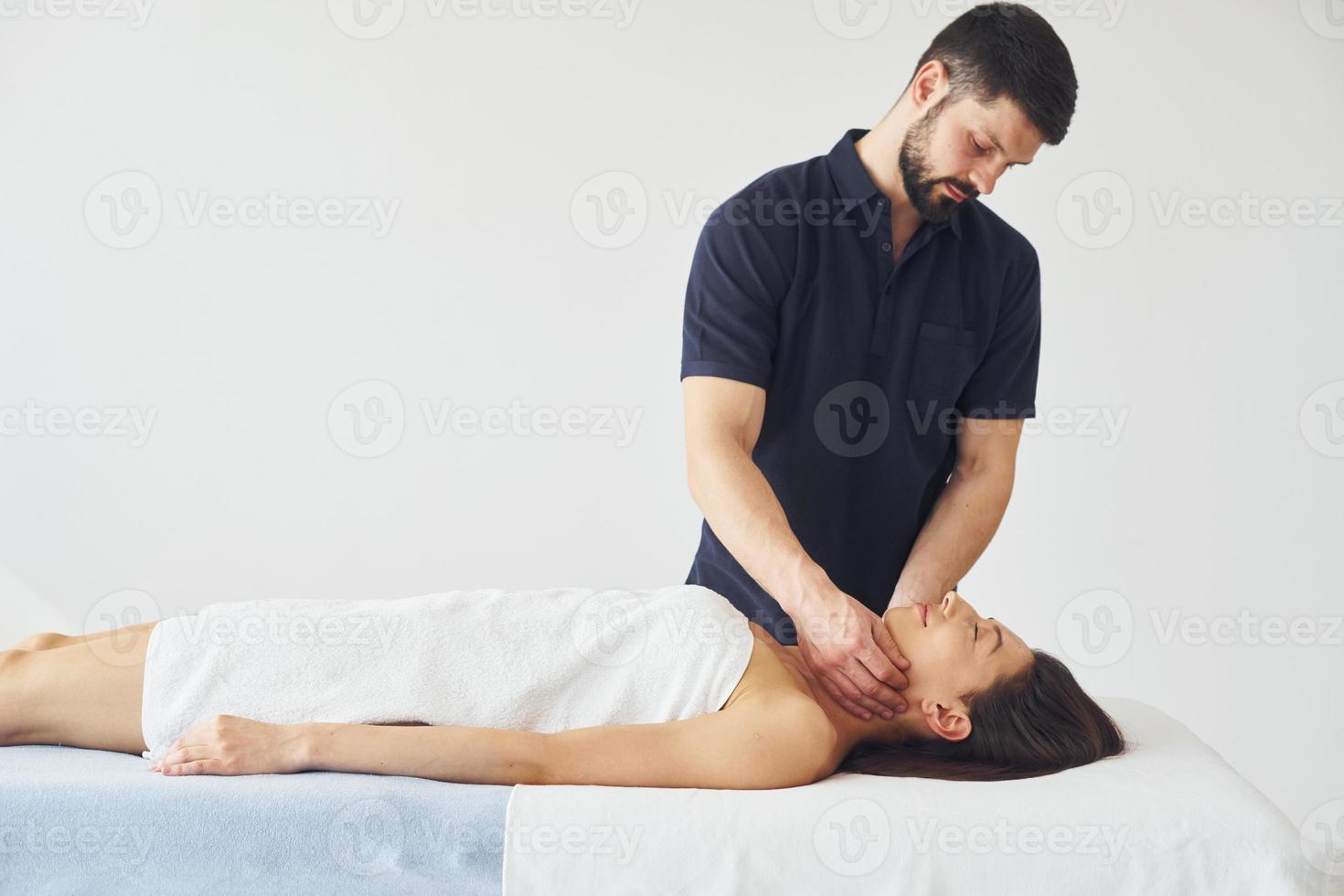 massage crânien. une jeune femme est allongée quand un homme lui fait une procédure au spa photo