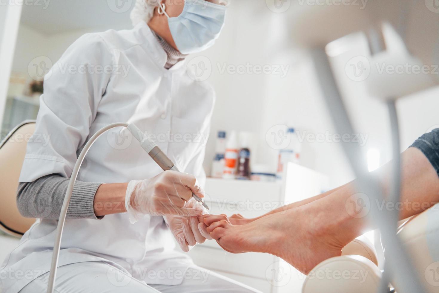 femme allongée et opérée des pieds par un professionnel de la clinique photo