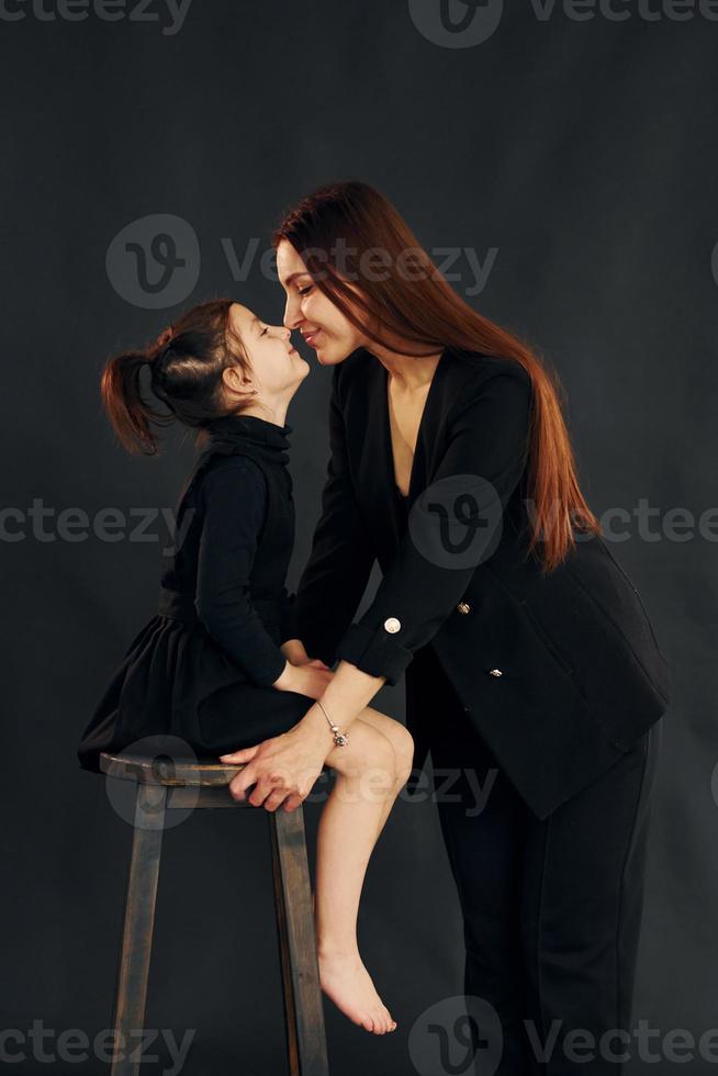 mère et fille sont ensemble dans le studio sur fond noir photo