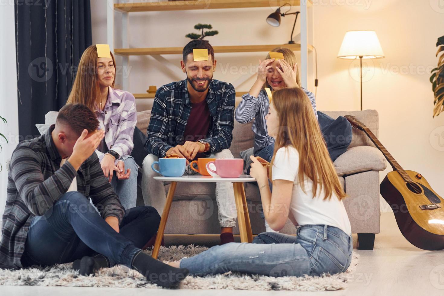 jouer qui suis-je jeu. un groupe d'amis fait la fête ensemble à l'intérieur photo