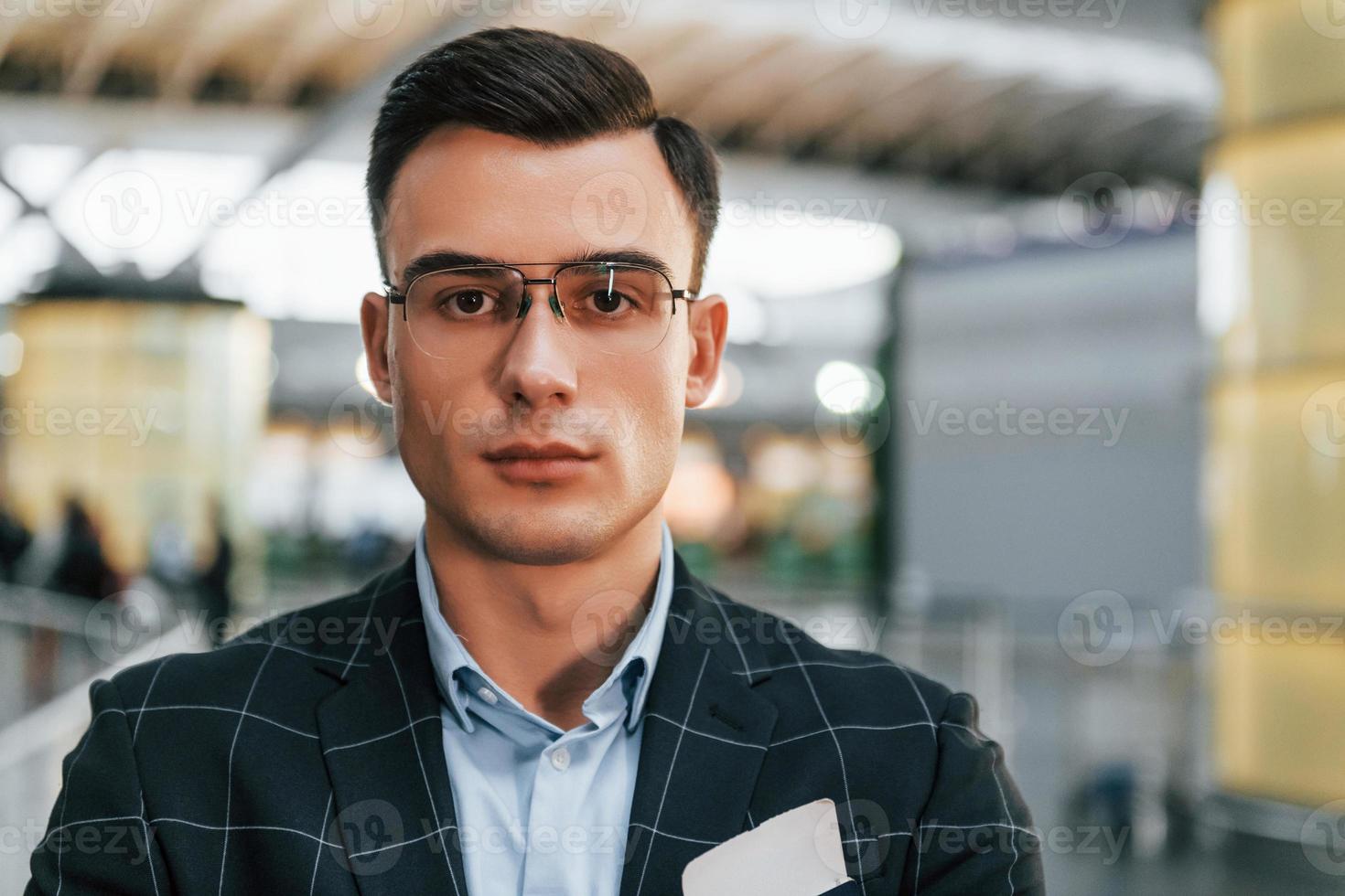 jeune homme d'affaires en vêtements formels est à l'aéroport pendant la journée photo