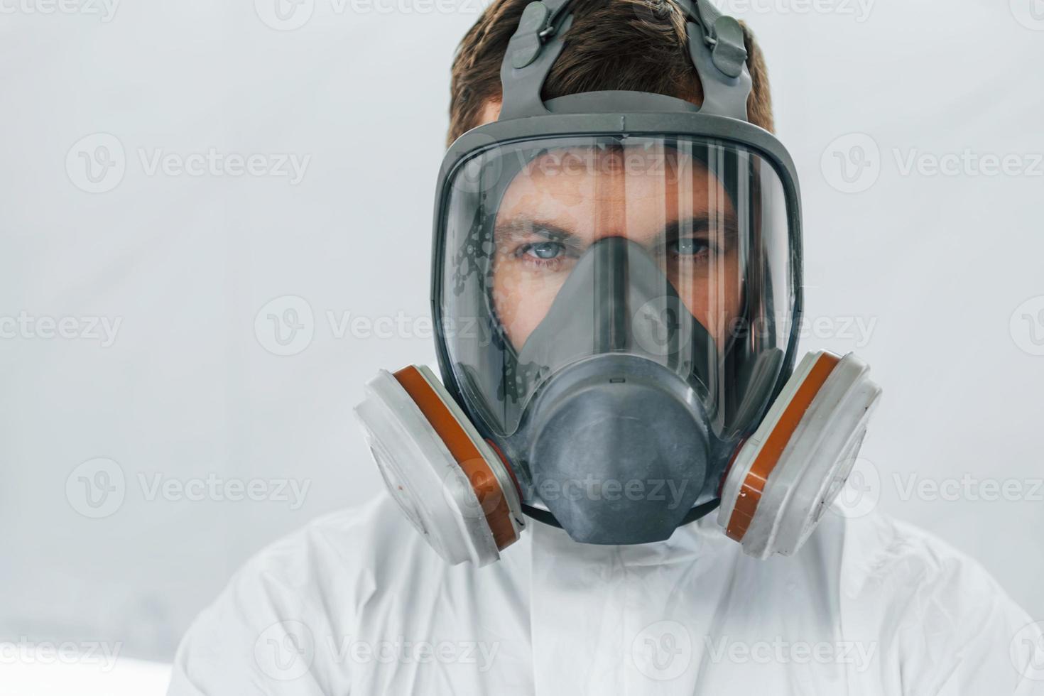 portrait d'homme au masque de protection. travailleur en uniforme est dans le service automobile photo