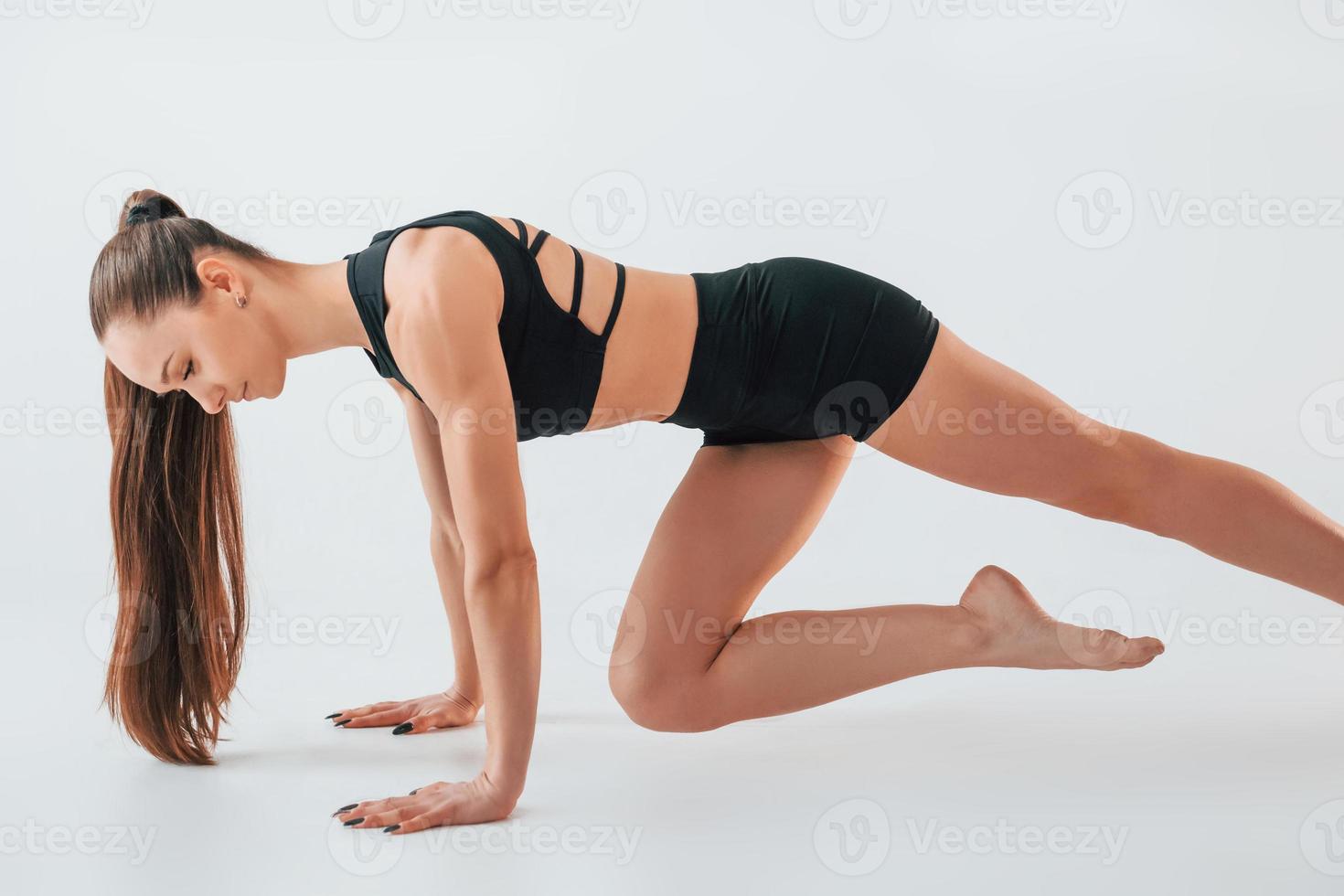 conception d'un mode de vie actif. jeune femme en vêtements sportifs faisant de la gymnastique à l'intérieur photo