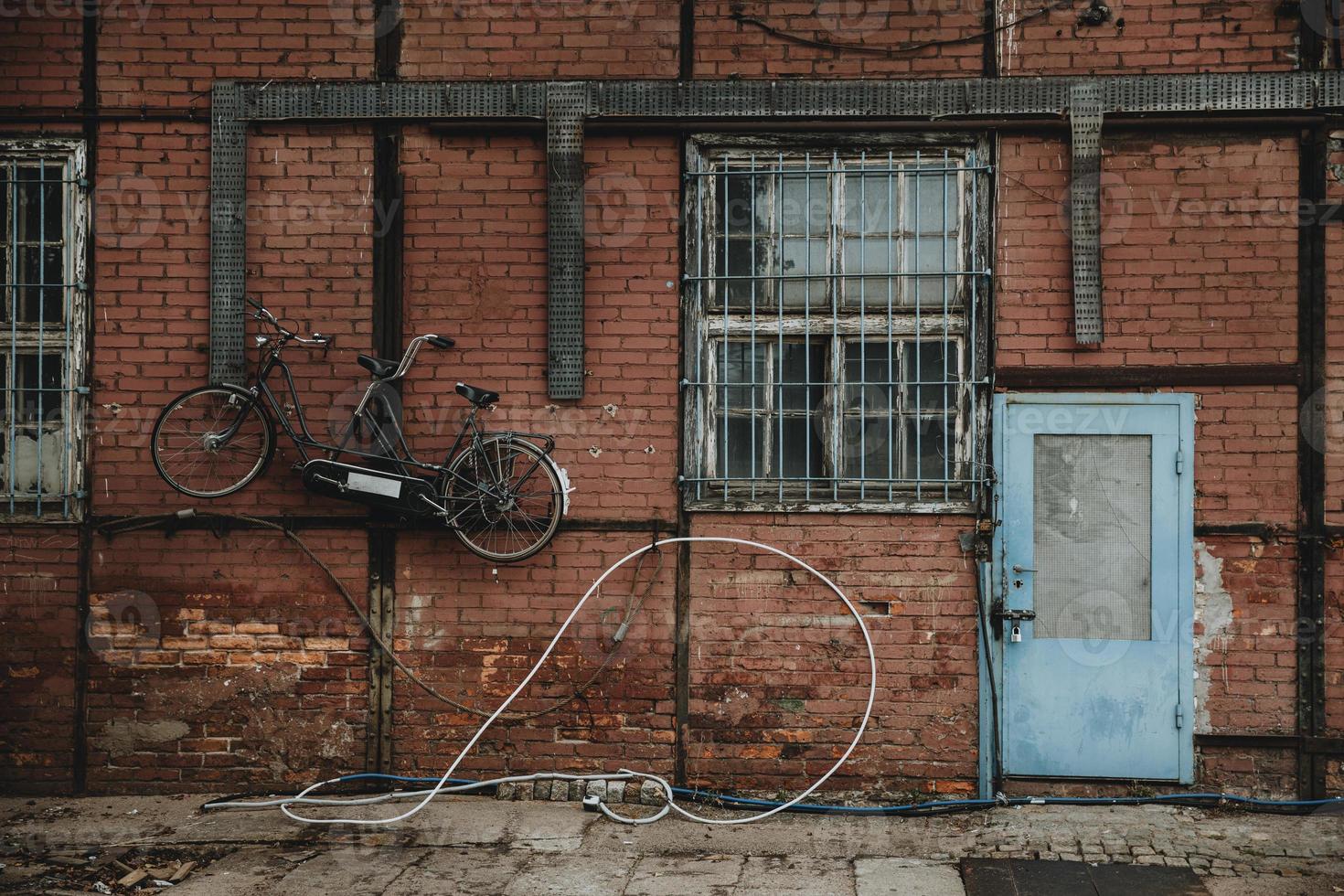 porte bleue dans un mur de briques rouges d'un bâtiment à colombages avec vélo tandem accroché au mur dans les quais de gdansk photo