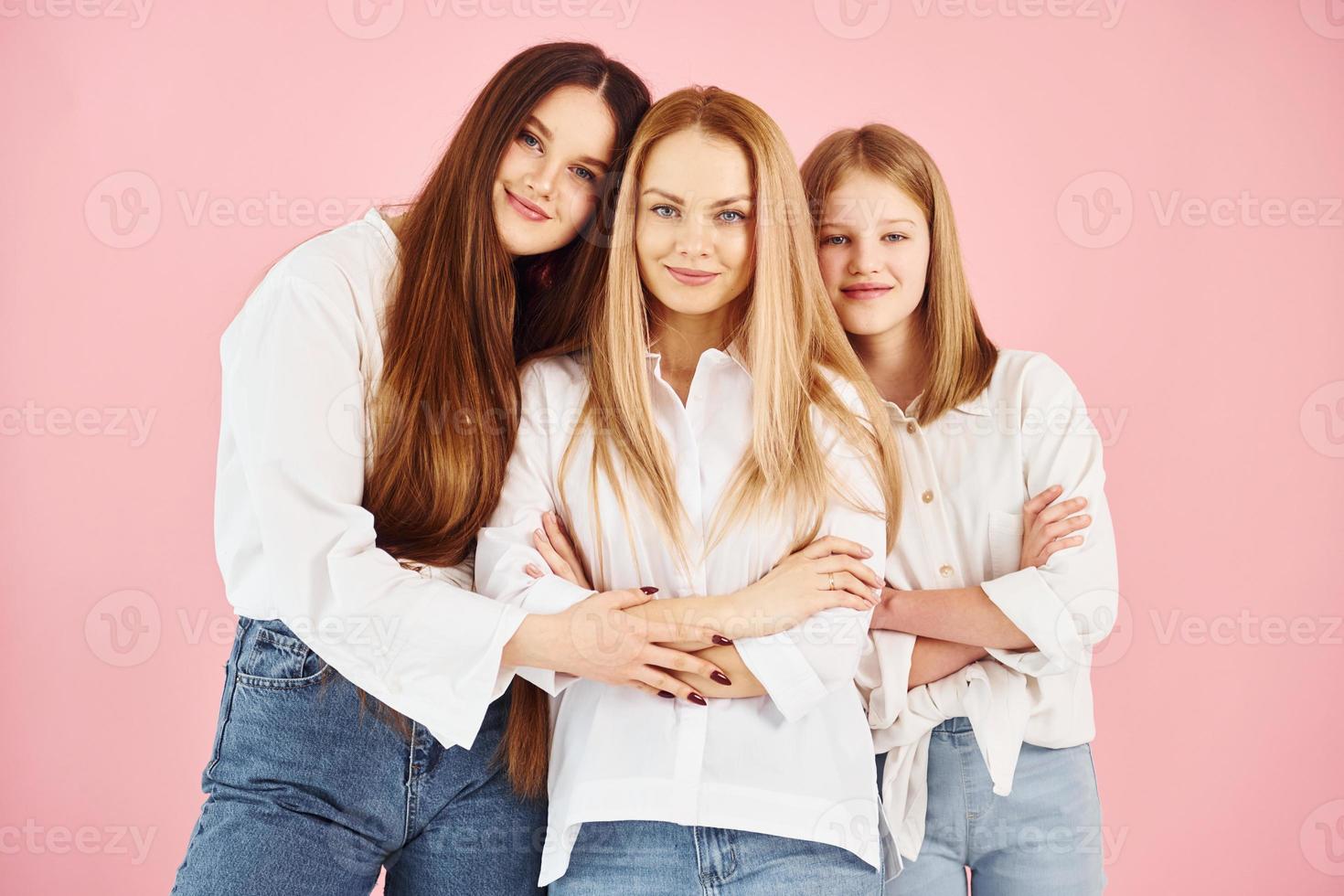 posant pour un appareil photo. jeune mère avec ses deux filles est en studio photo