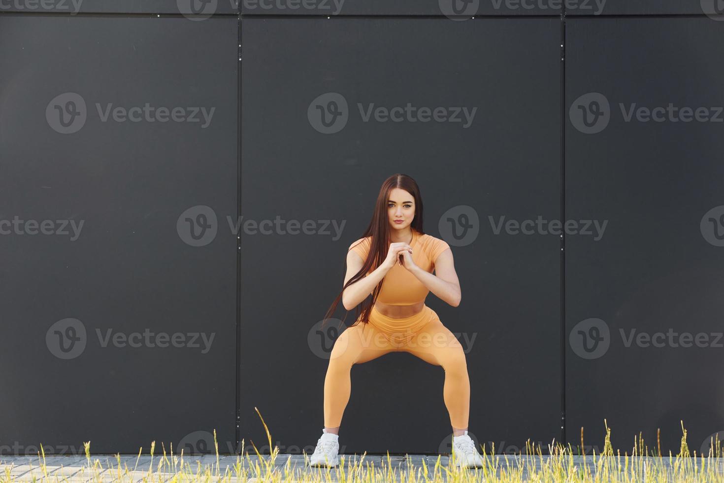 des exercices d'étirement. jeune femme en vêtements de sport a une séance de fitness à l'extérieur photo