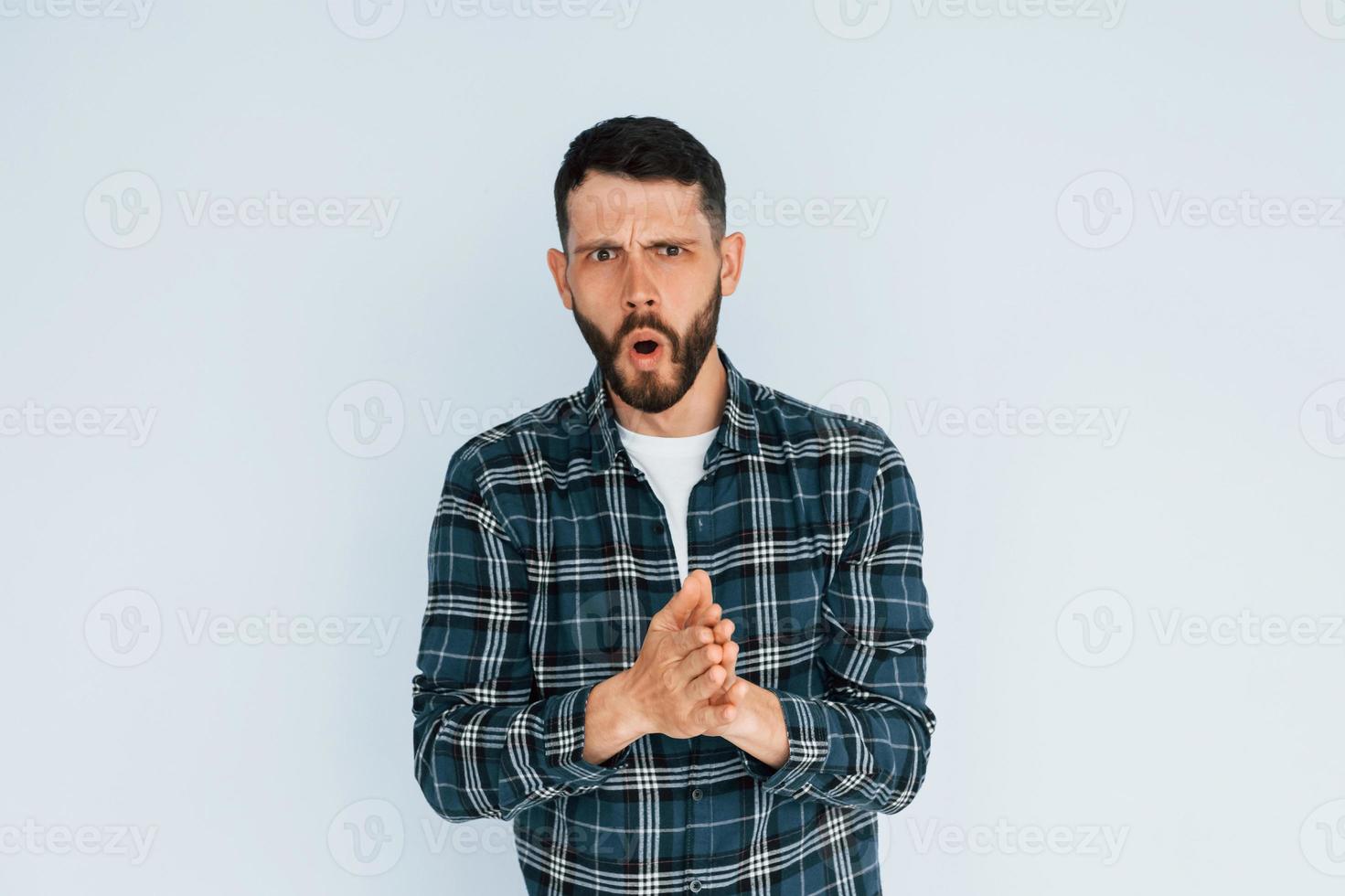 regarde dans la caméra. jeune homme en vêtements décontractés debout à l'intérieur dans le studio photo