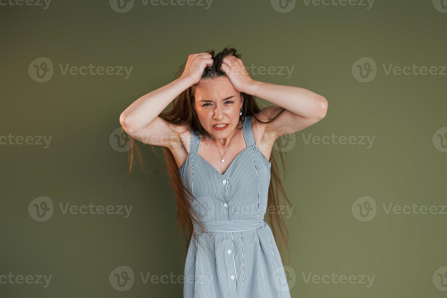 démonstration d'émotions. jeune femme en vêtements décontractés debout à l'intérieur dans le studio photo