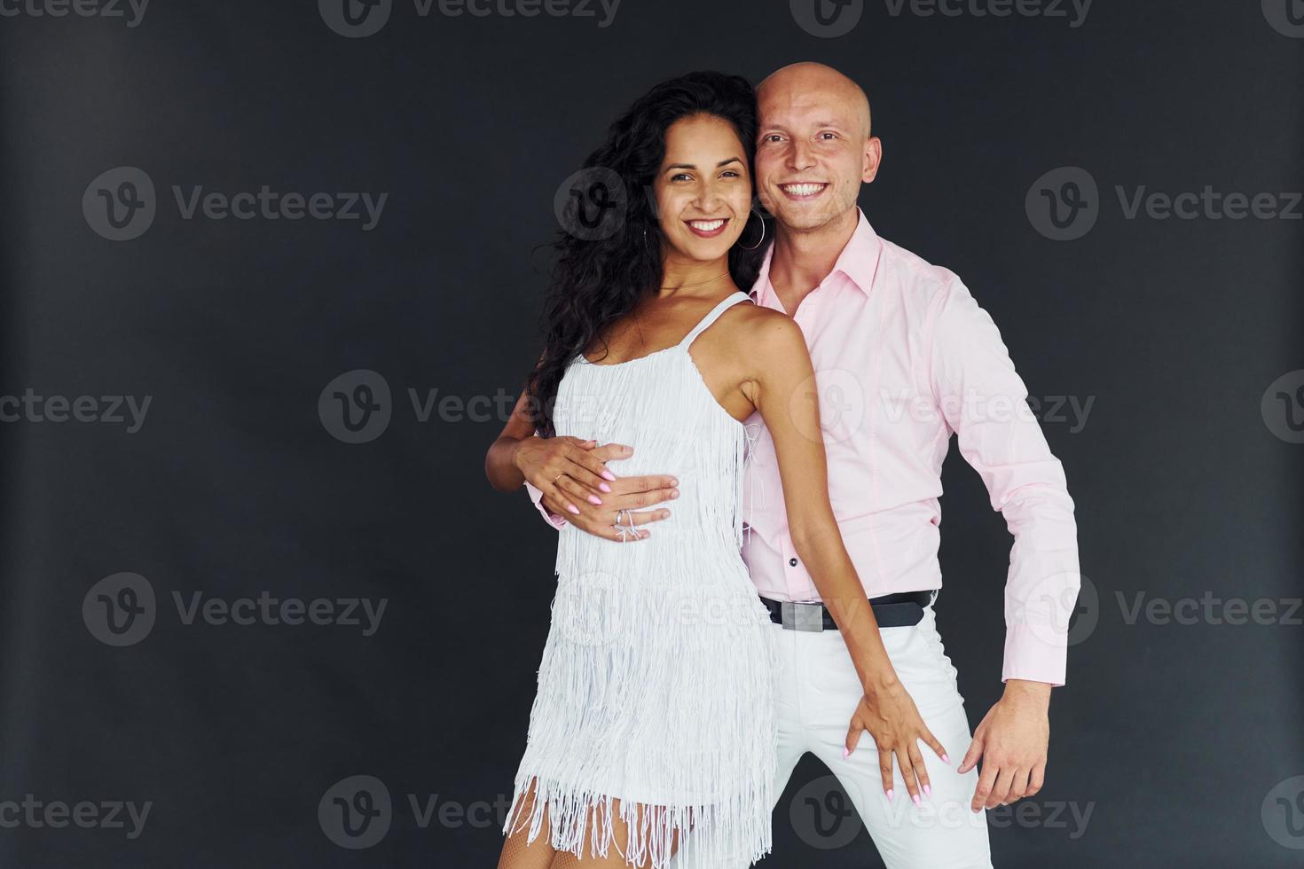 danse sur fond noir. joyeux couple est ensemble à l'intérieur photo