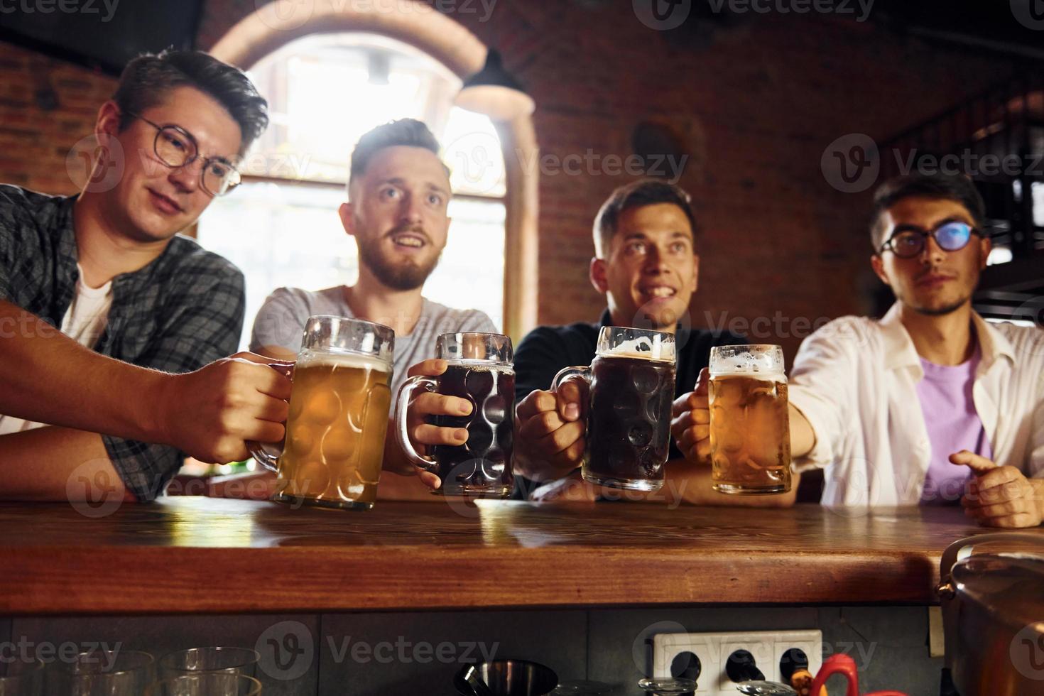 boire de la bière. gens en vêtements décontractés assis dans le pub photo