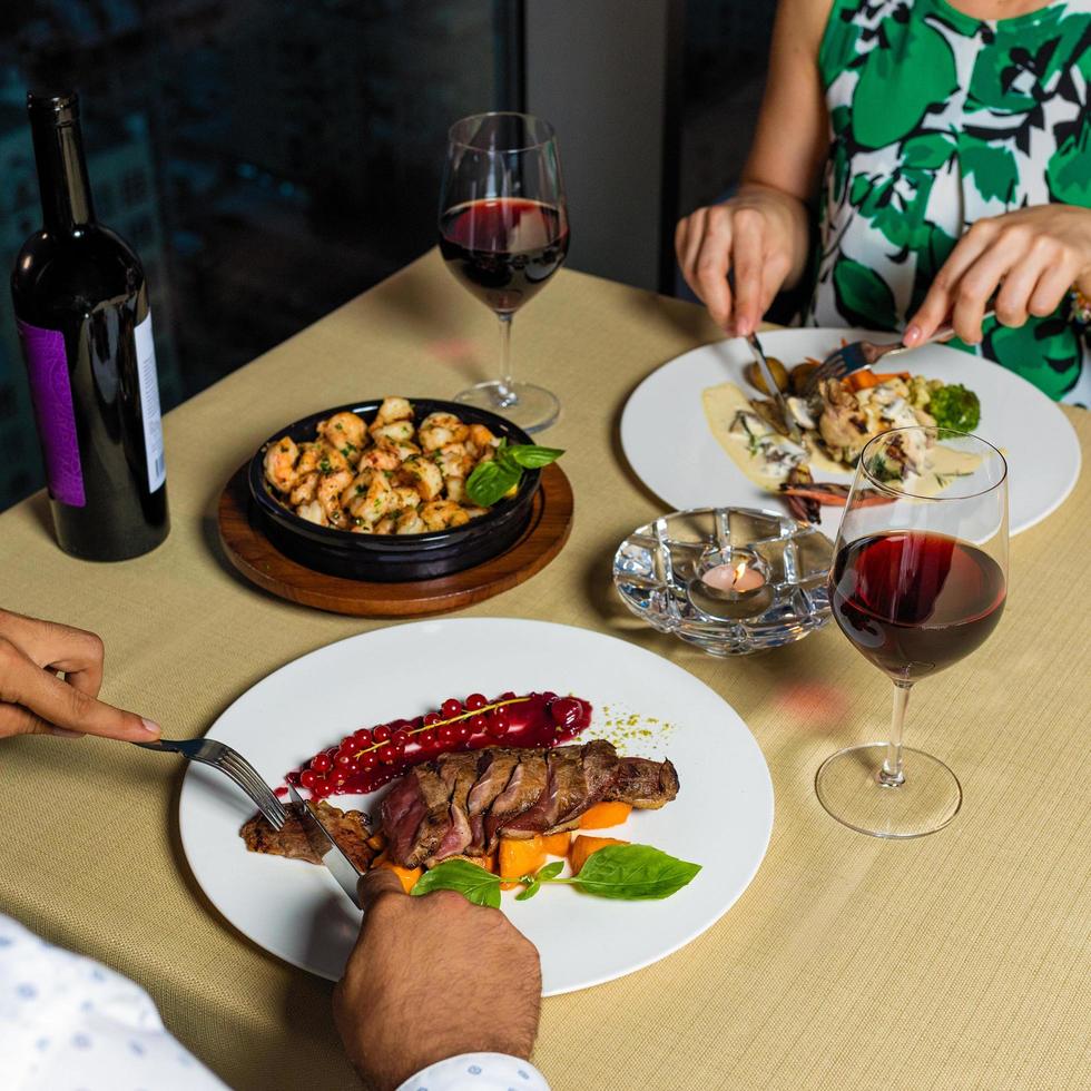 couple au dîner manger steak avec du vin photo