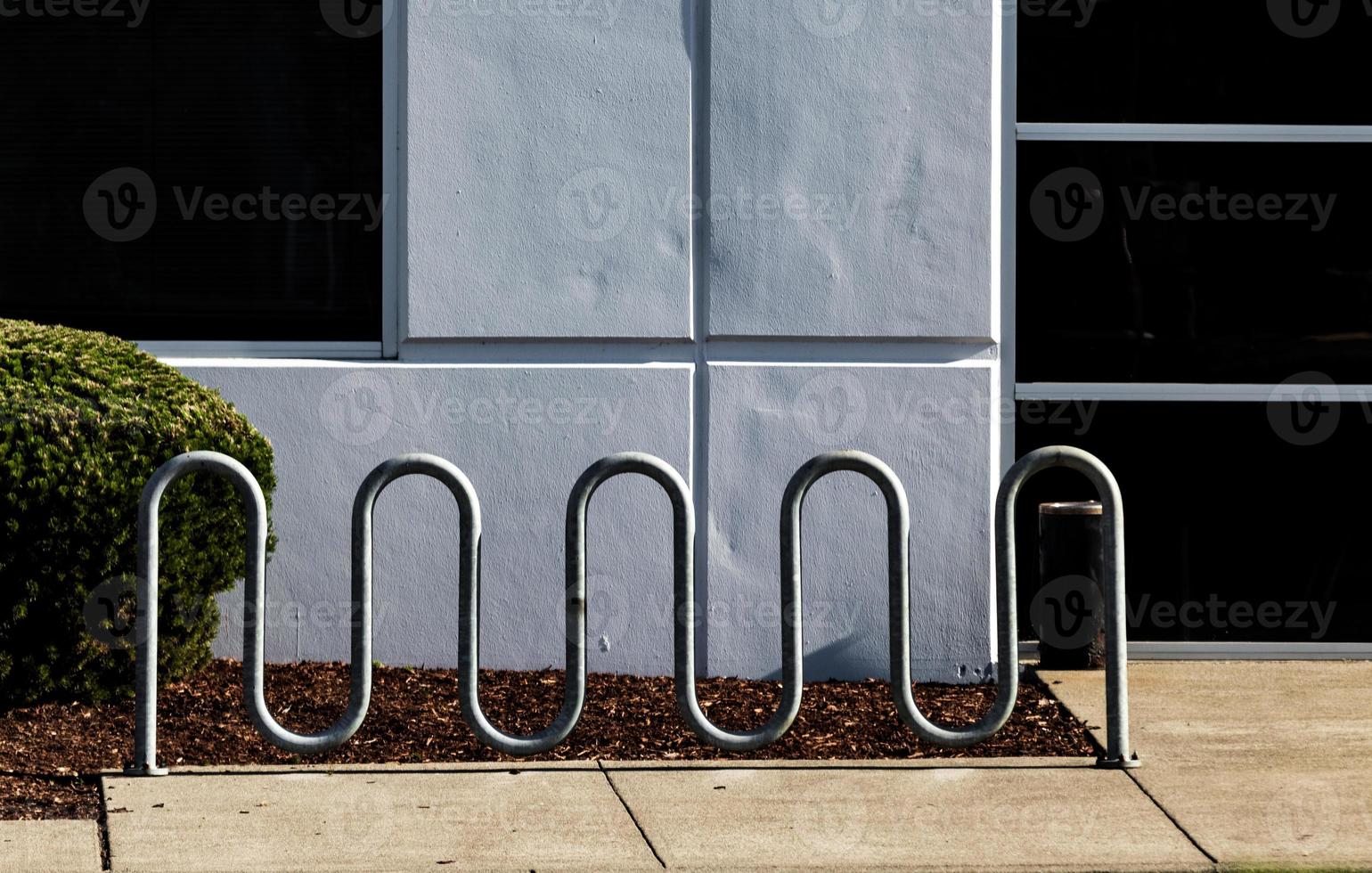 porte-vélos tout en courbes devant un mur blanc photo