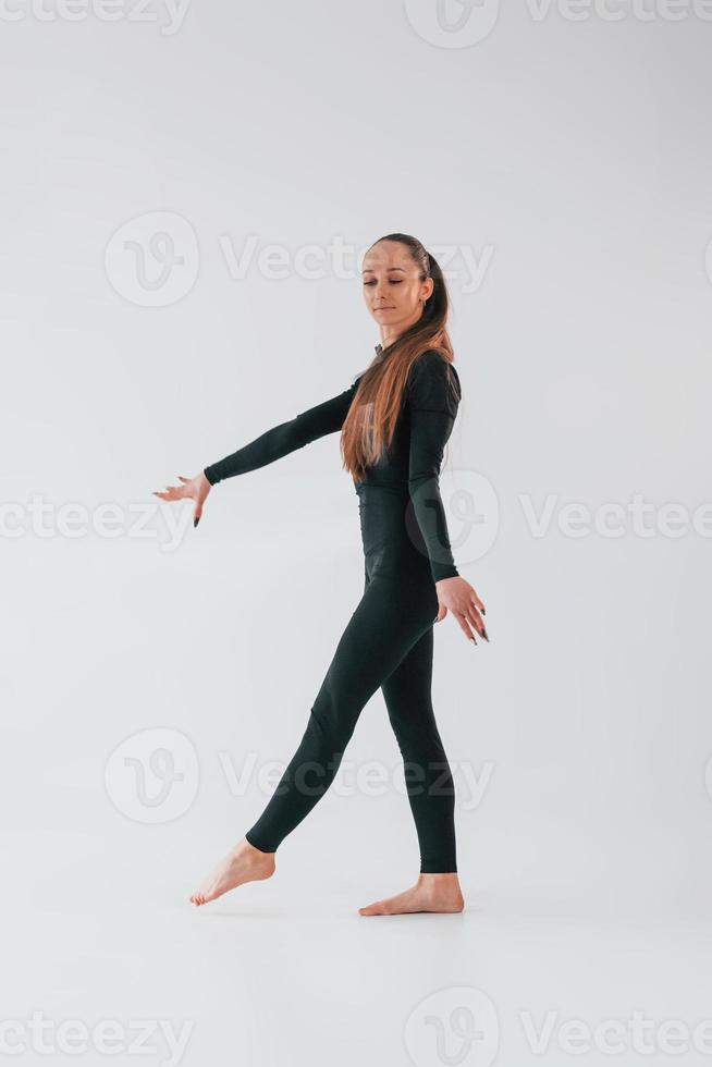 sur fond blanc. jeune femme en vêtements sportifs faisant de la gymnastique à l'intérieur photo