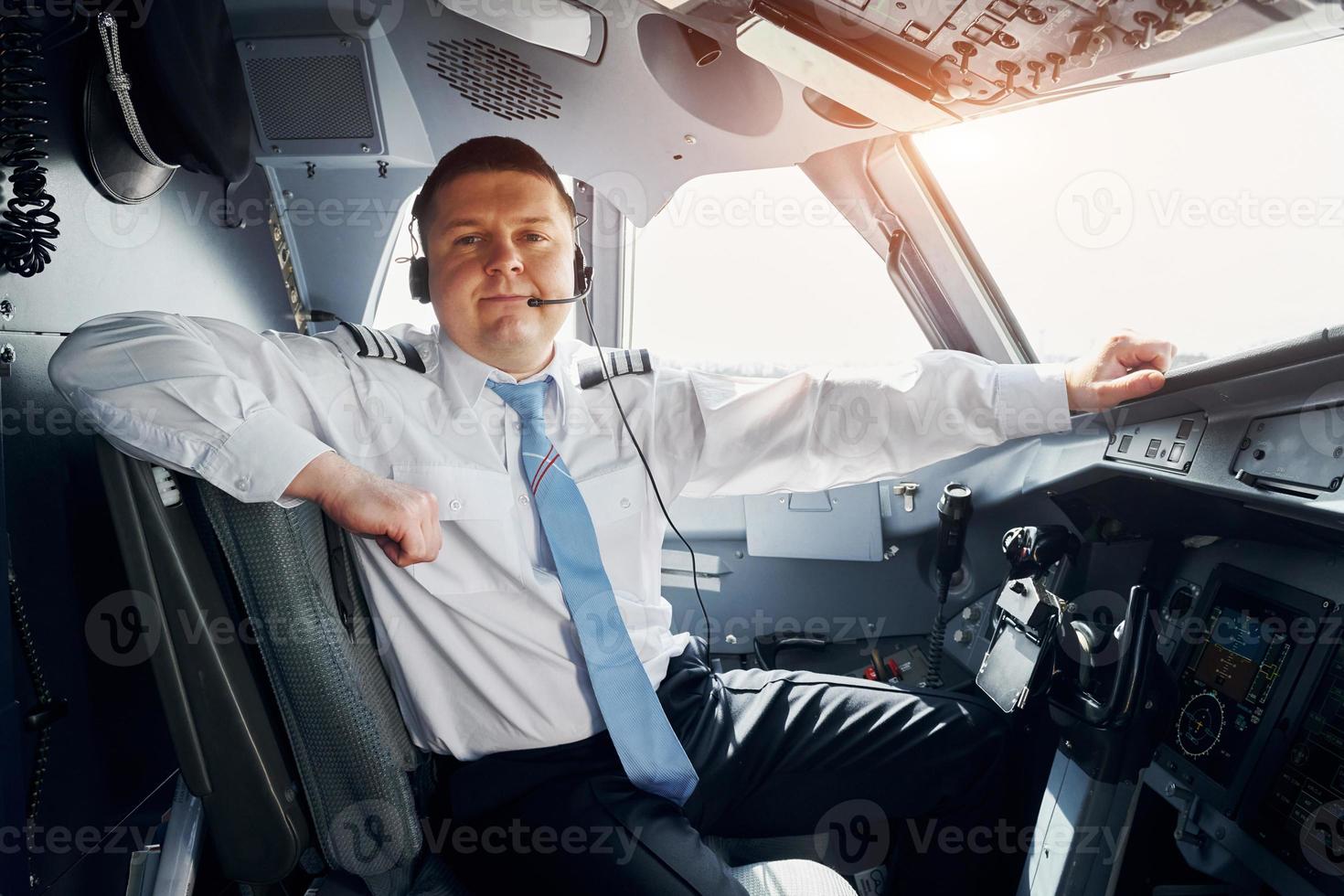 le pilote en tenue de soirée est assis dans le cockpit et contrôle l'avion photo