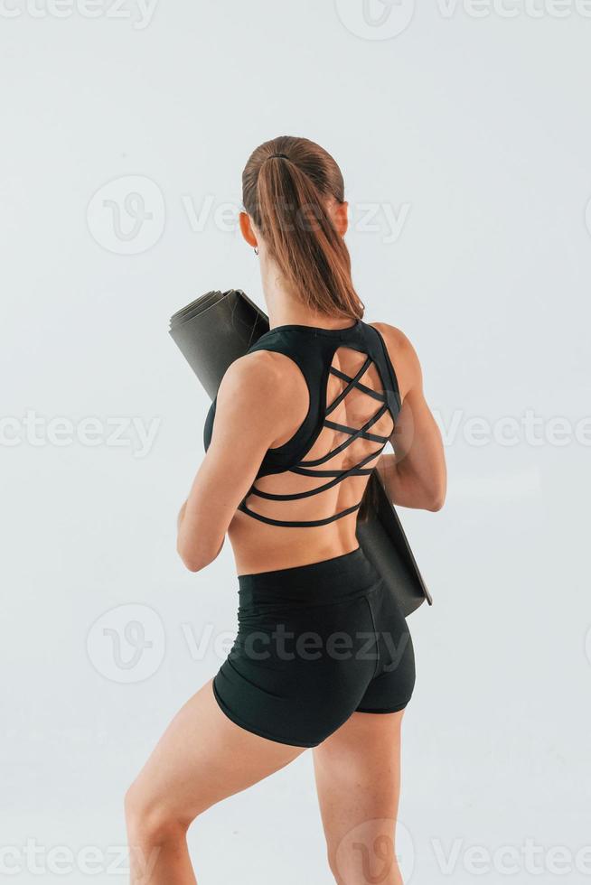 conception d'un mode de vie actif. jeune femme en vêtements sportifs faisant de la gymnastique à l'intérieur photo