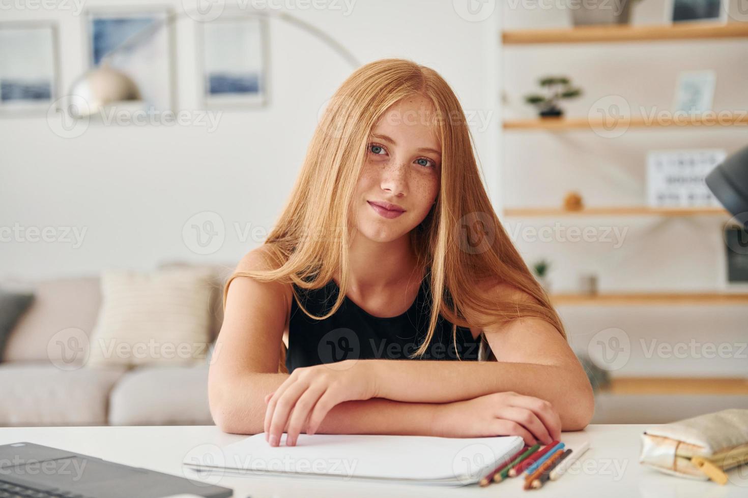 posant pour un appareil photo. Une adolescente aux cheveux blonds est à la maison pendant la journée photo