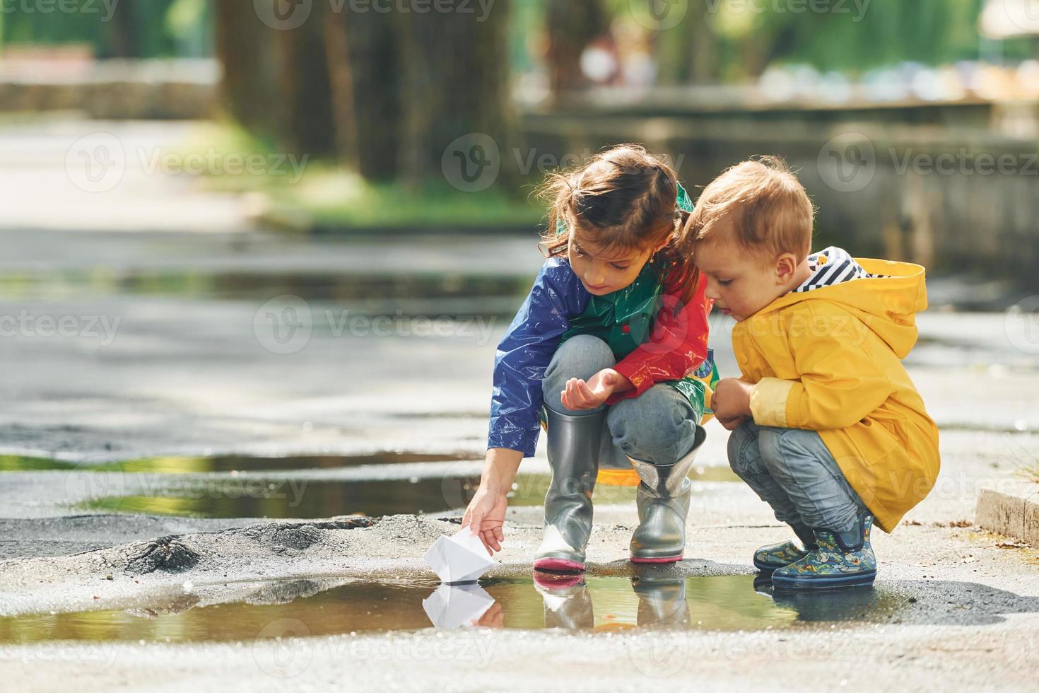 dans la flaque. les enfants s'amusent dehors dans le parc après la pluie photo