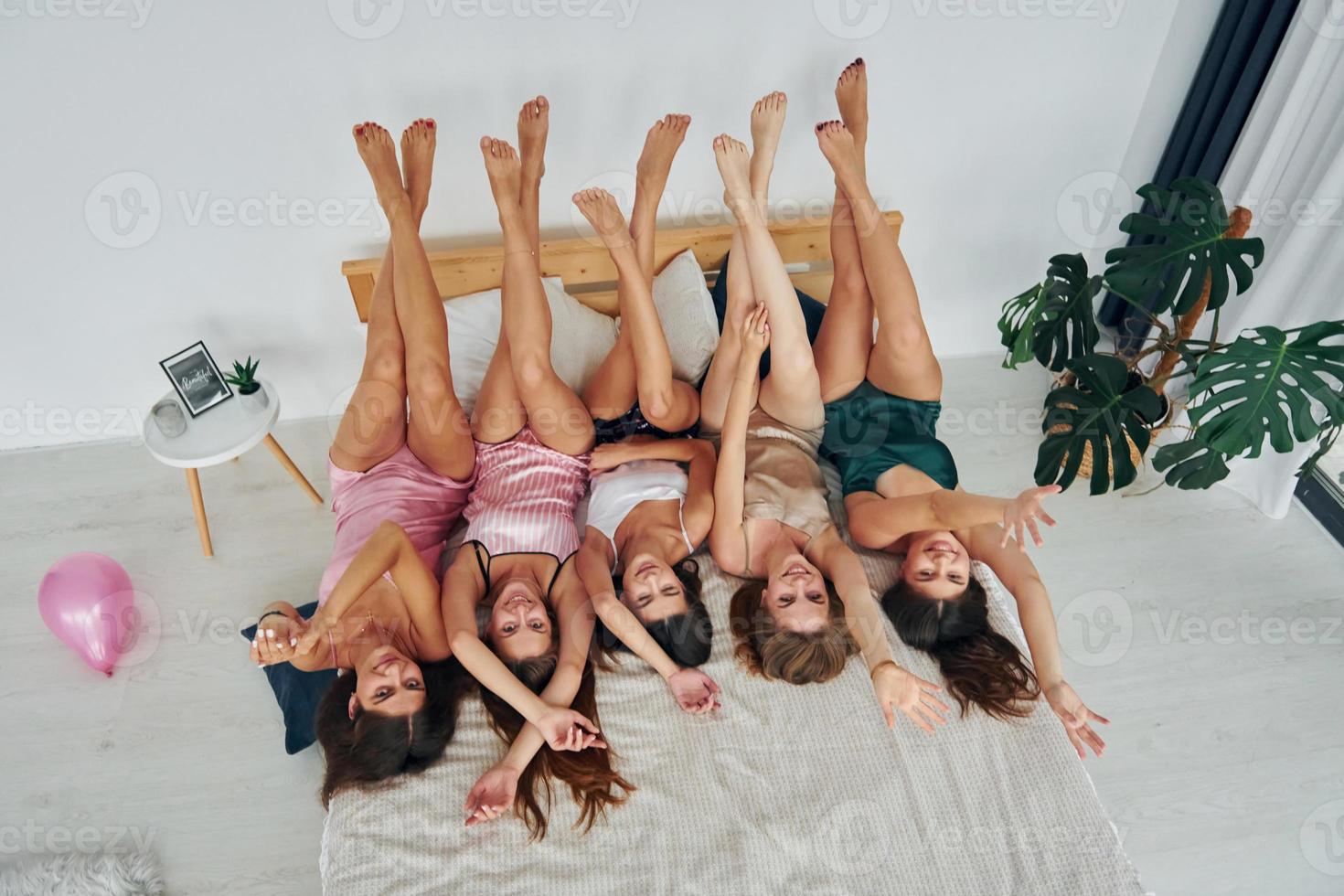avec les jambes vers le haut. groupe de femmes heureuses sexy qui est à un enterrement de vie de jeune fille photo