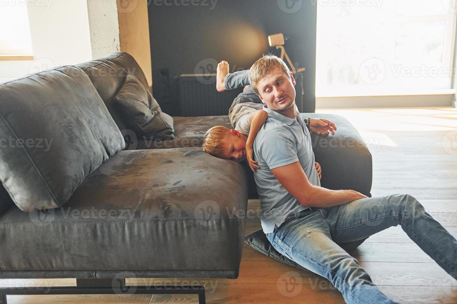 s'amuser. père et fils sont à l'intérieur à la maison ensemble photo