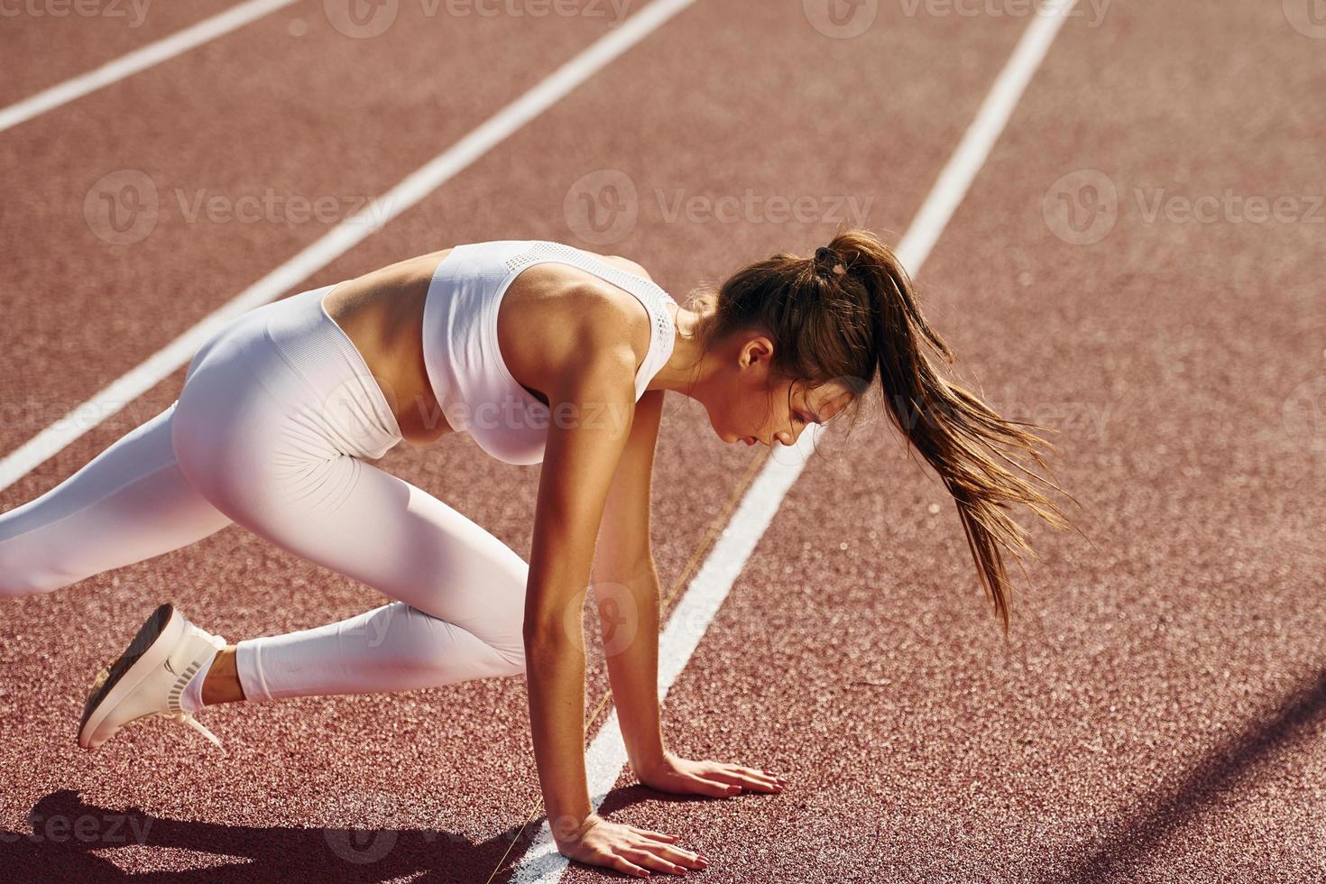 des exercices d'étirement. jeune femme en vêtements sportifs fait du fitness à l'extérieur photo