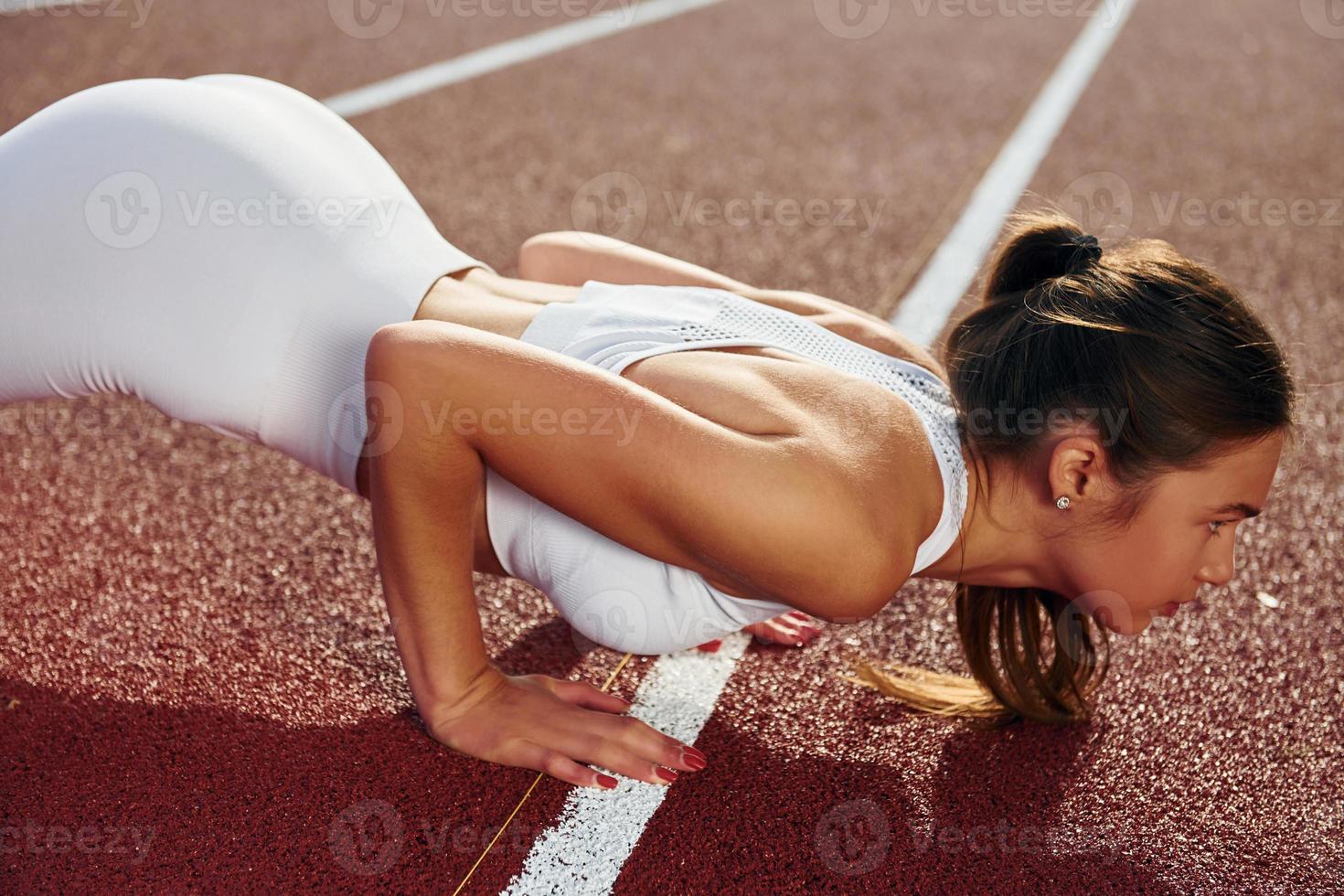 la femme est sur la piste de course s'exerçant à l'extérieur photo