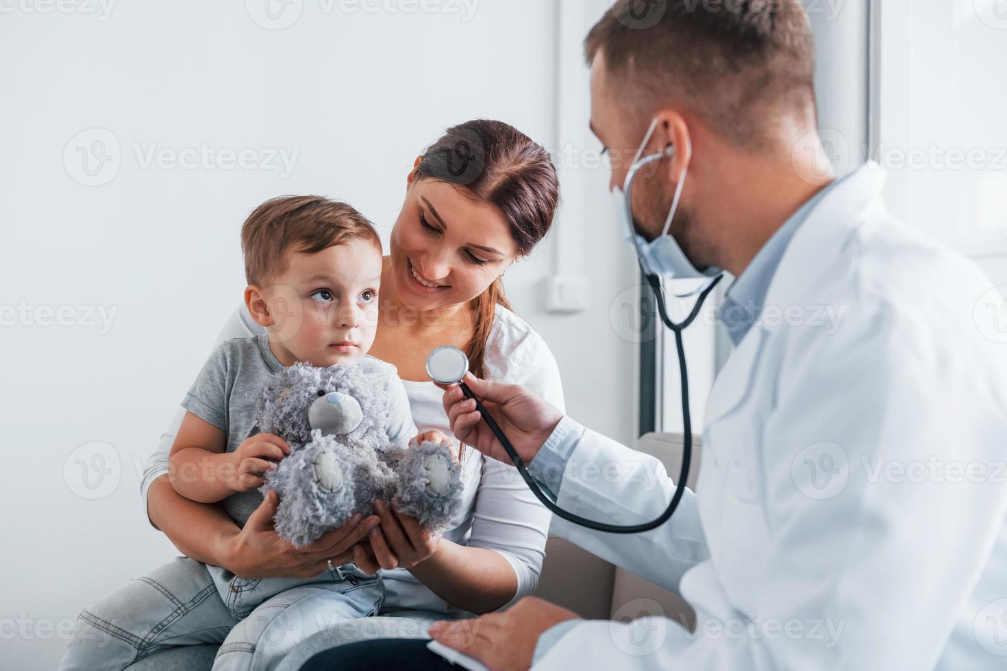 aider l'enfant. deux médecins en blouse blanche travaillent ensemble à la clinique photo