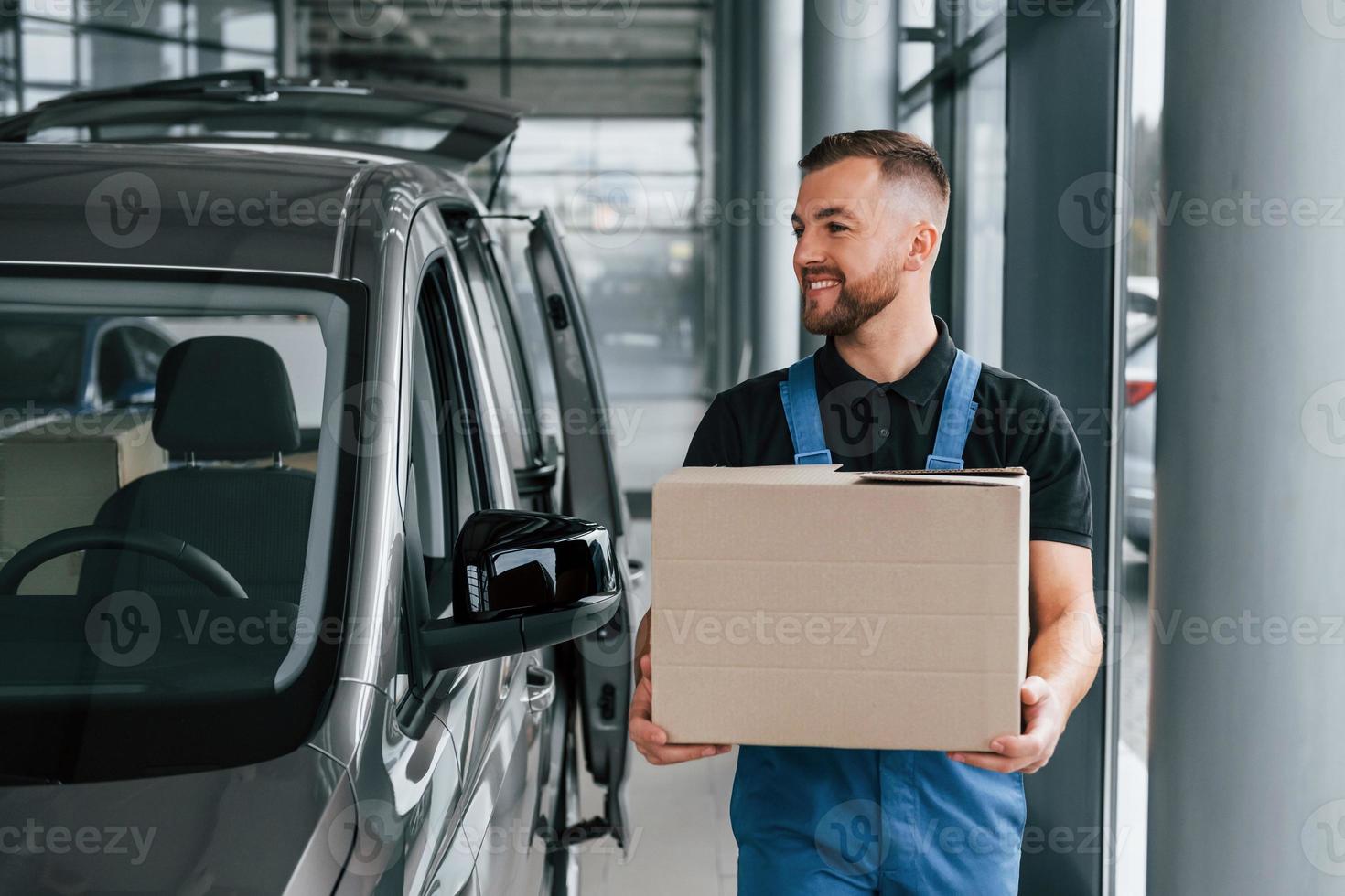 boîte en papier. livreur en uniforme est à l'intérieur avec voiture et avec commande photo