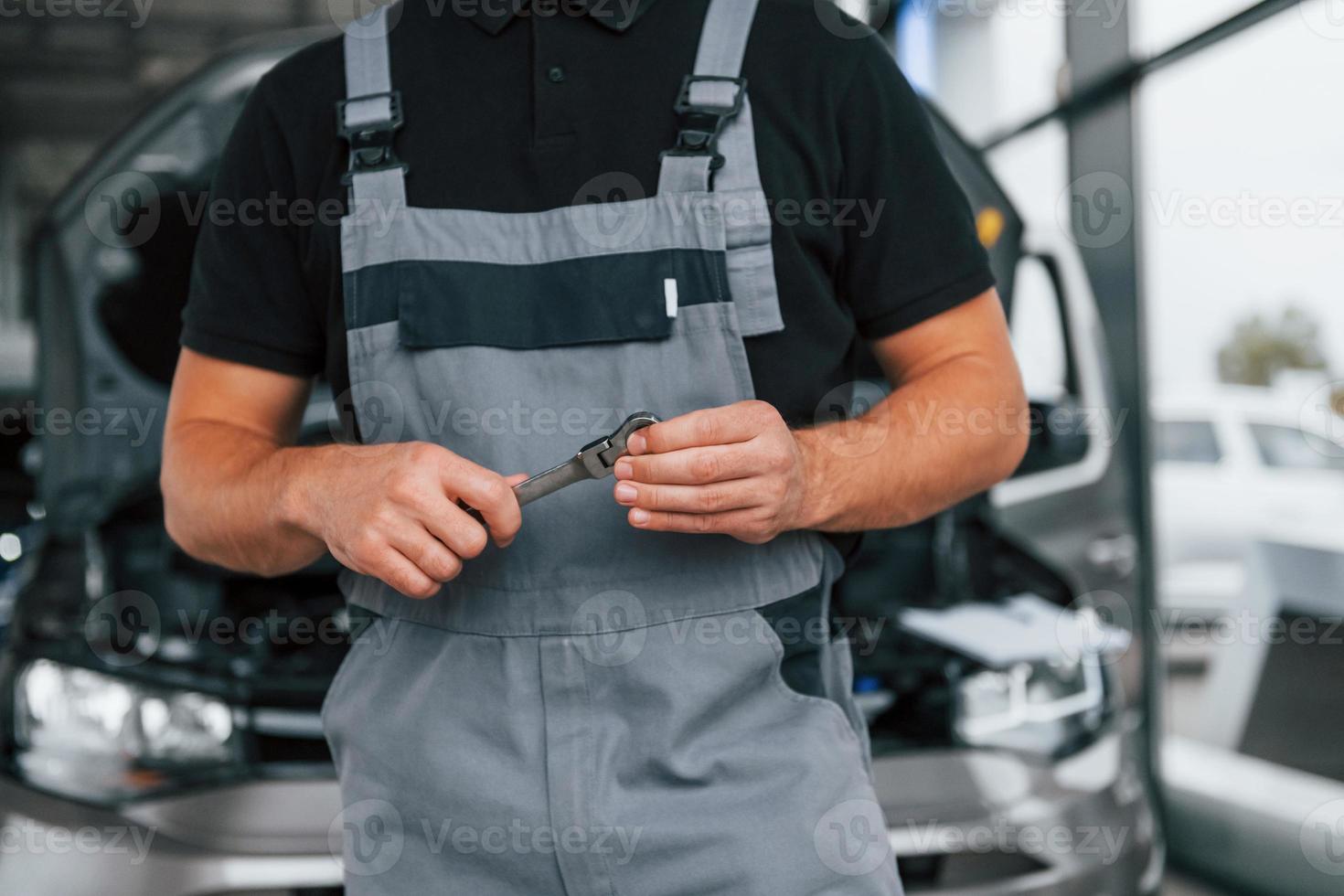 vue rapprochée. un homme en uniforme travaille dans l'autosalon pendant la journée photo