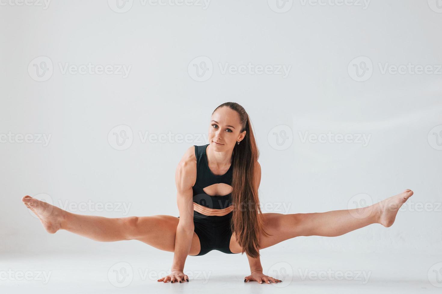 debout sur les mains. jeune femme en vêtements sportifs faisant de la gymnastique à l'intérieur photo