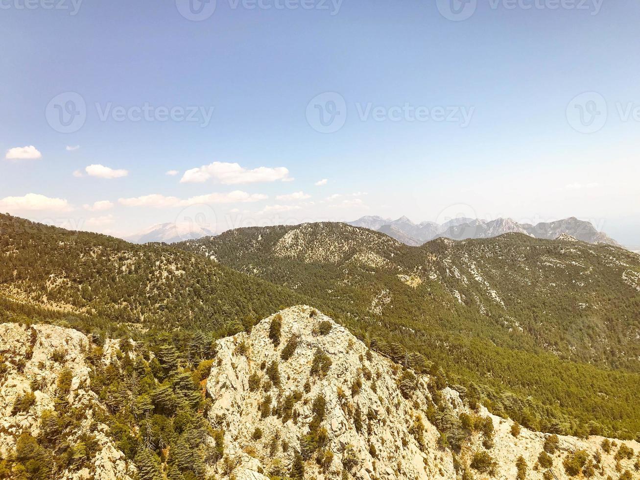 montagnes dans un pays chaud et tropical contre un ciel bleu. des plantes vertes, des arbres et des buissons poussent sur les montagnes. vue à vol d'oiseau photo