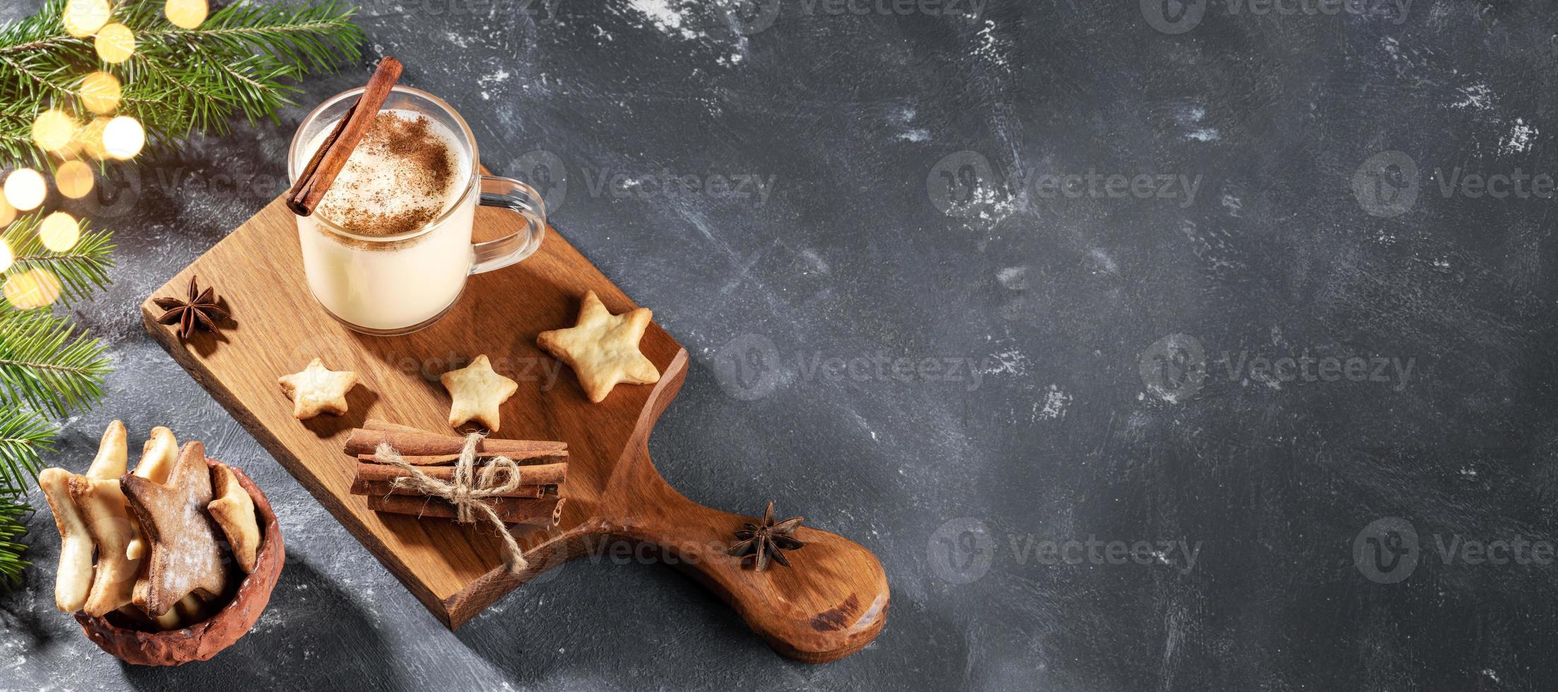 bannière avec lait de poule de noël, biscuits en forme de coeur et branches de sapin avec lumières bokeh sur gris. photo