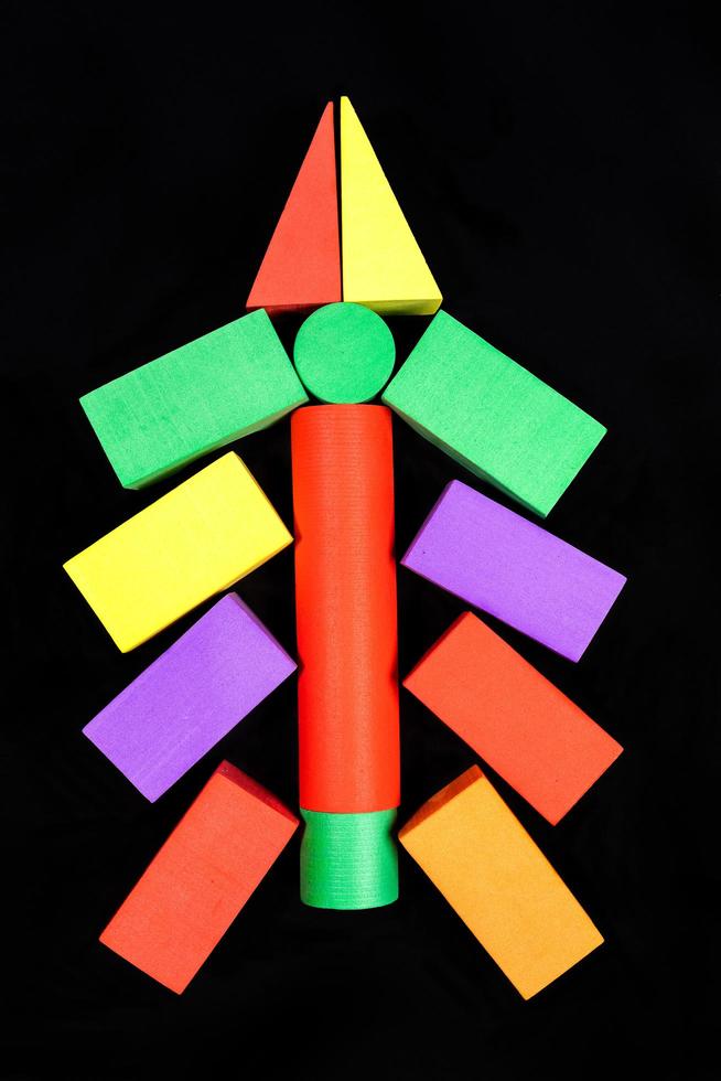 vue de dessus sur l'arbre de noël composé de cubes mous pour enfants sur fond noir se bouchent. photo